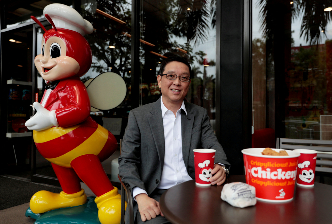 Ernesto Tanmantiong, president and CEO of Jollibee Foods Corp., poses with Jollibee products outside a Jollibee branch in Pasig City, Metro Manila, the Philippines, July 30, 2019.