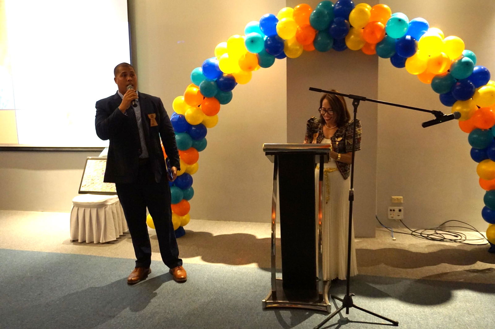 Rotarian of the Year Billy Grow addresses his fellow Rotarians while standing next to outgoing Club President Irene Holl.