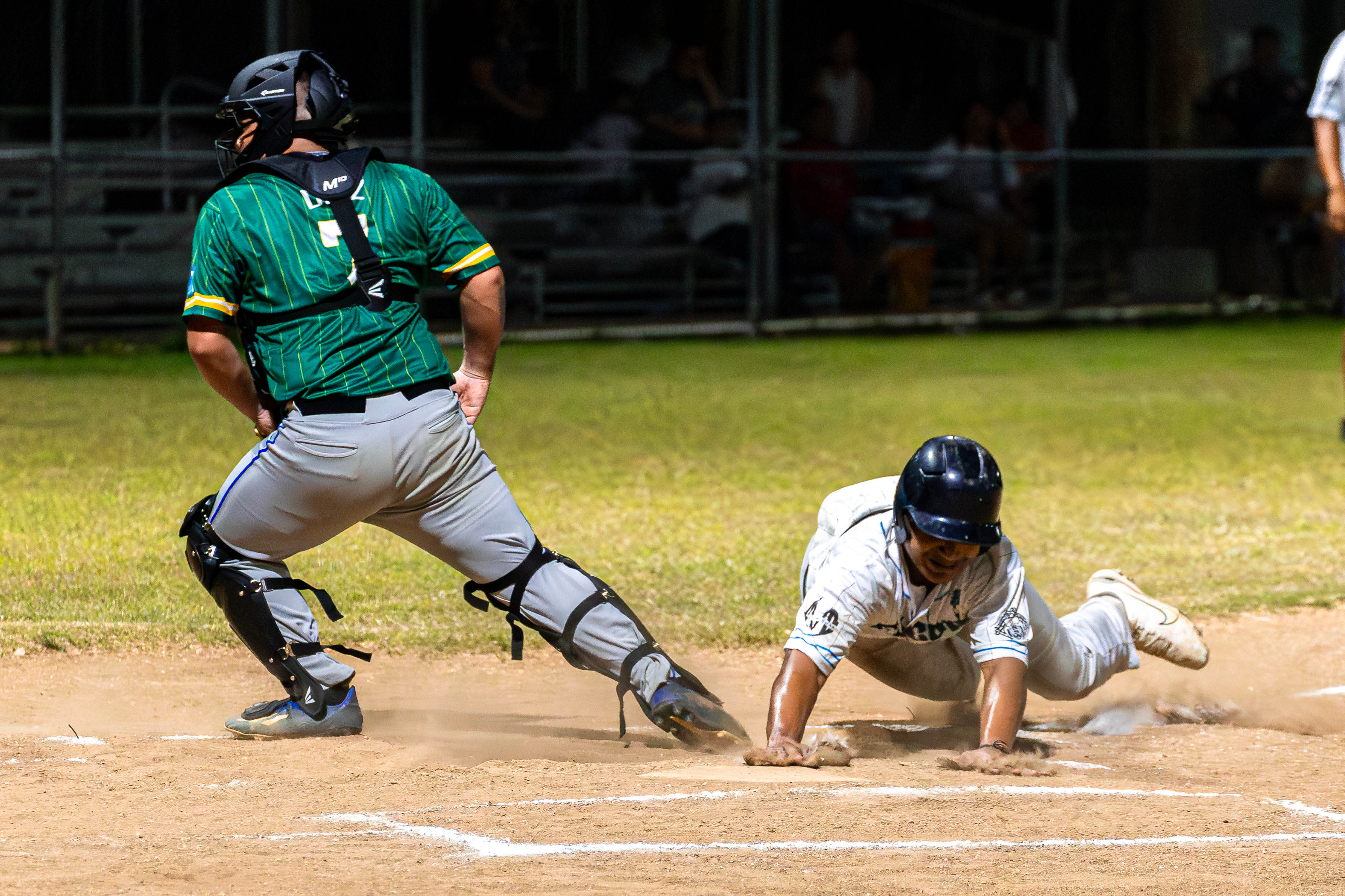 The Falcon's Jon Norita slides home to beat Sandlot catcher Luis Diaz for a scored run during a game in the 2024 Tan Holdings Saipan Baseball League at the Francisco "Tan Ko" Palacios Baseball Field on Tuesday.