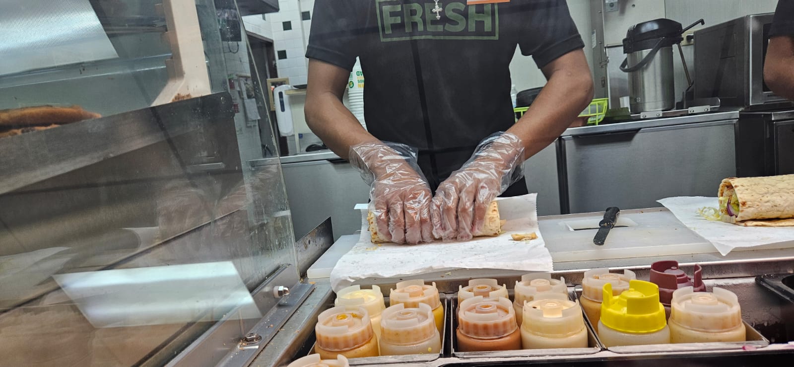 A Subway staff member prepares a wrap.