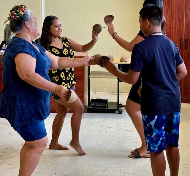 From left, Leilani Marciano and Bina Marciano teach the “Hafa Adai” dance at the Marianas Tourism Education Council and Marianas Visitors Authority’s outreach in Koblerville on July 24, 2024.