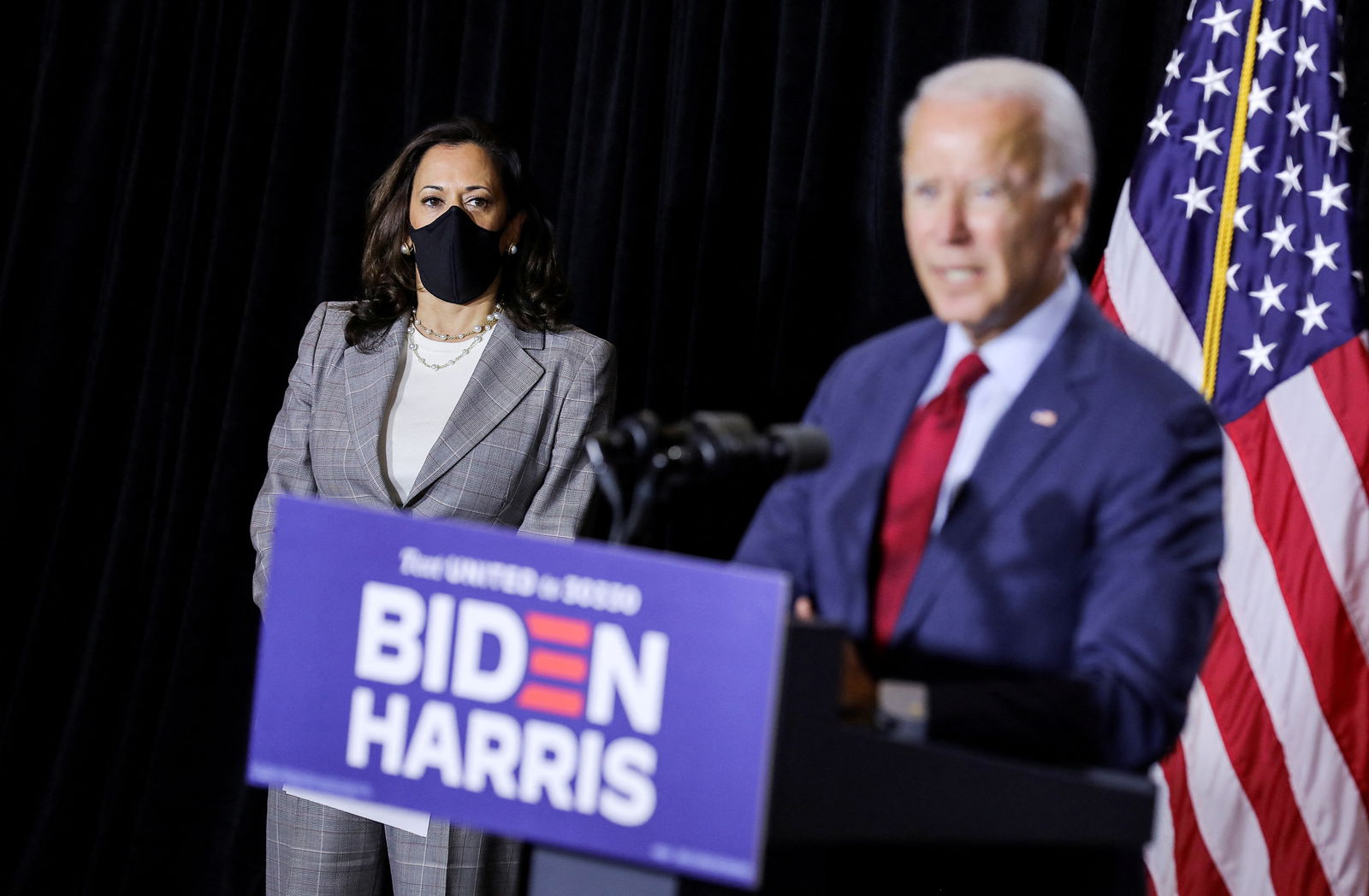 Democratic vice presidential candidate Kamala Harris listens as Democratic presidential candidate Joe Biden calls for the mandatory wearing of protective face masks as they face reporters after receiving a briefing on the coronavirus disease pandemic from public health officials during a campaign event in Wilmington, Delaware, Aug. 13, 2020.