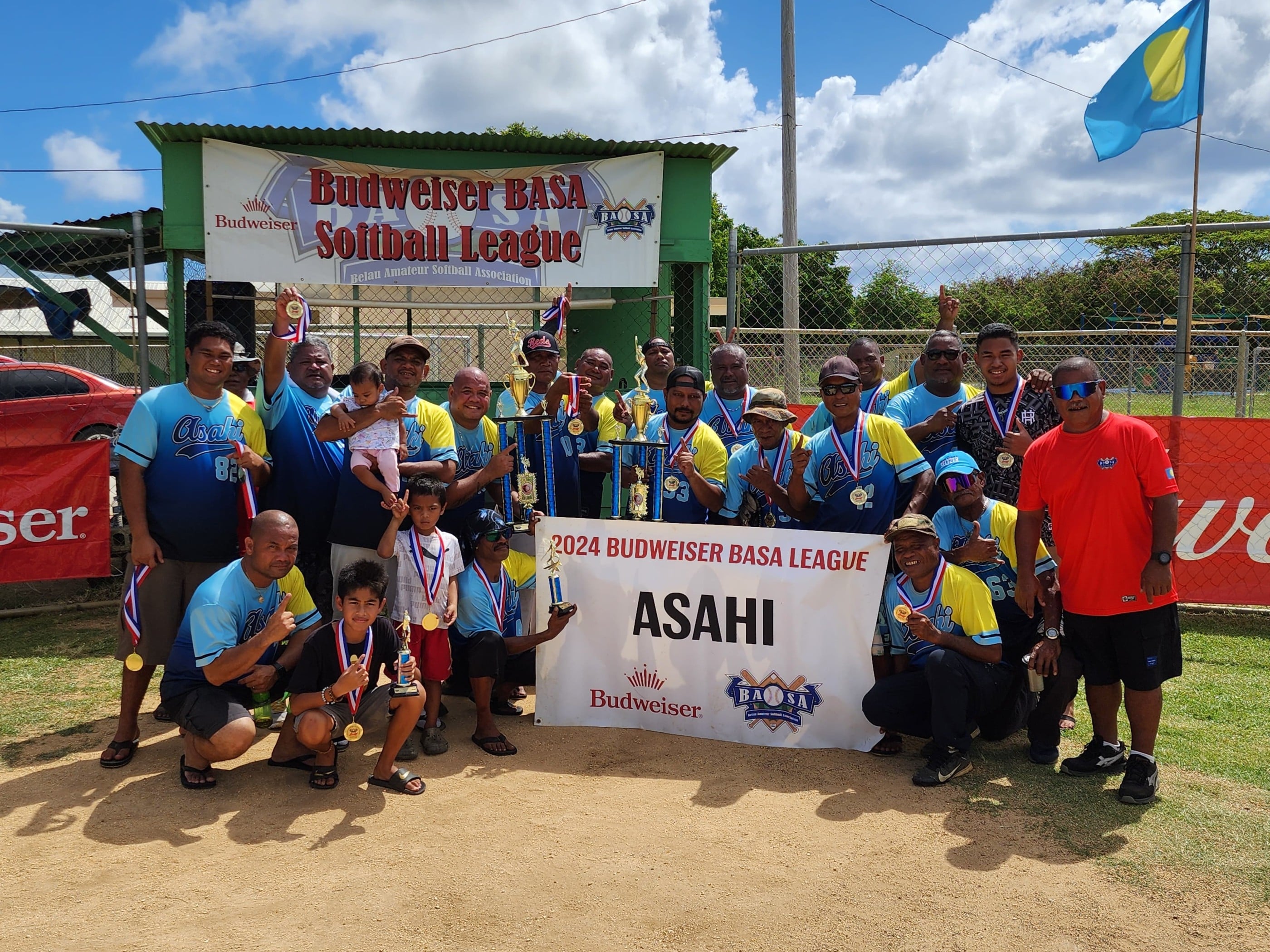 Asahi players pose with the championship trophy of the 2024 Belau Amateur Softball Association League after defeating SUFA in their best-of-three championship series at the Dandan baseball field on Sunday.