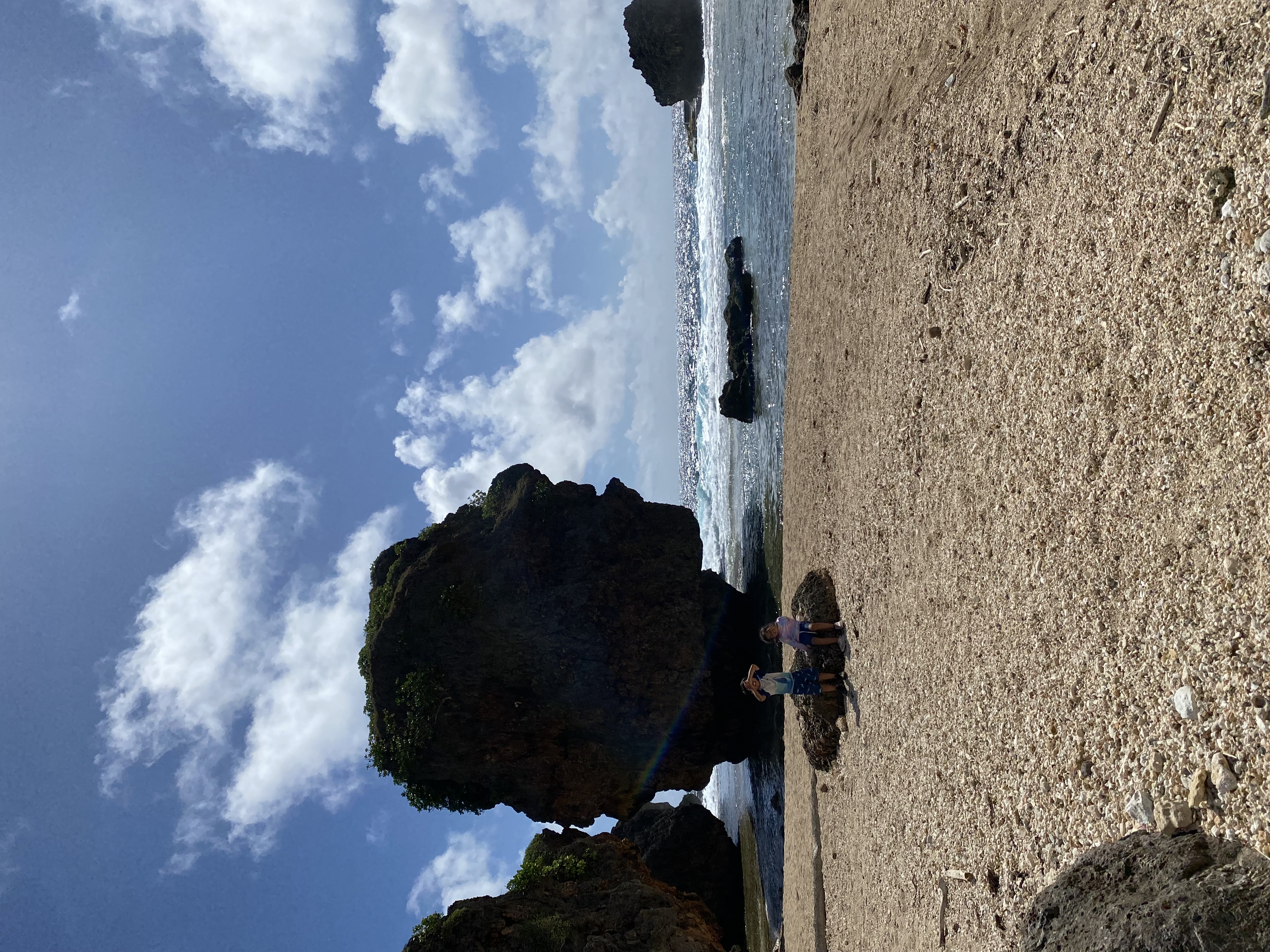 Two island children sit in front of the Old Man by the Sea, where a concerned citizen and the Rotaract Club of Saipan will conduct a beach cleanup on July 20. 