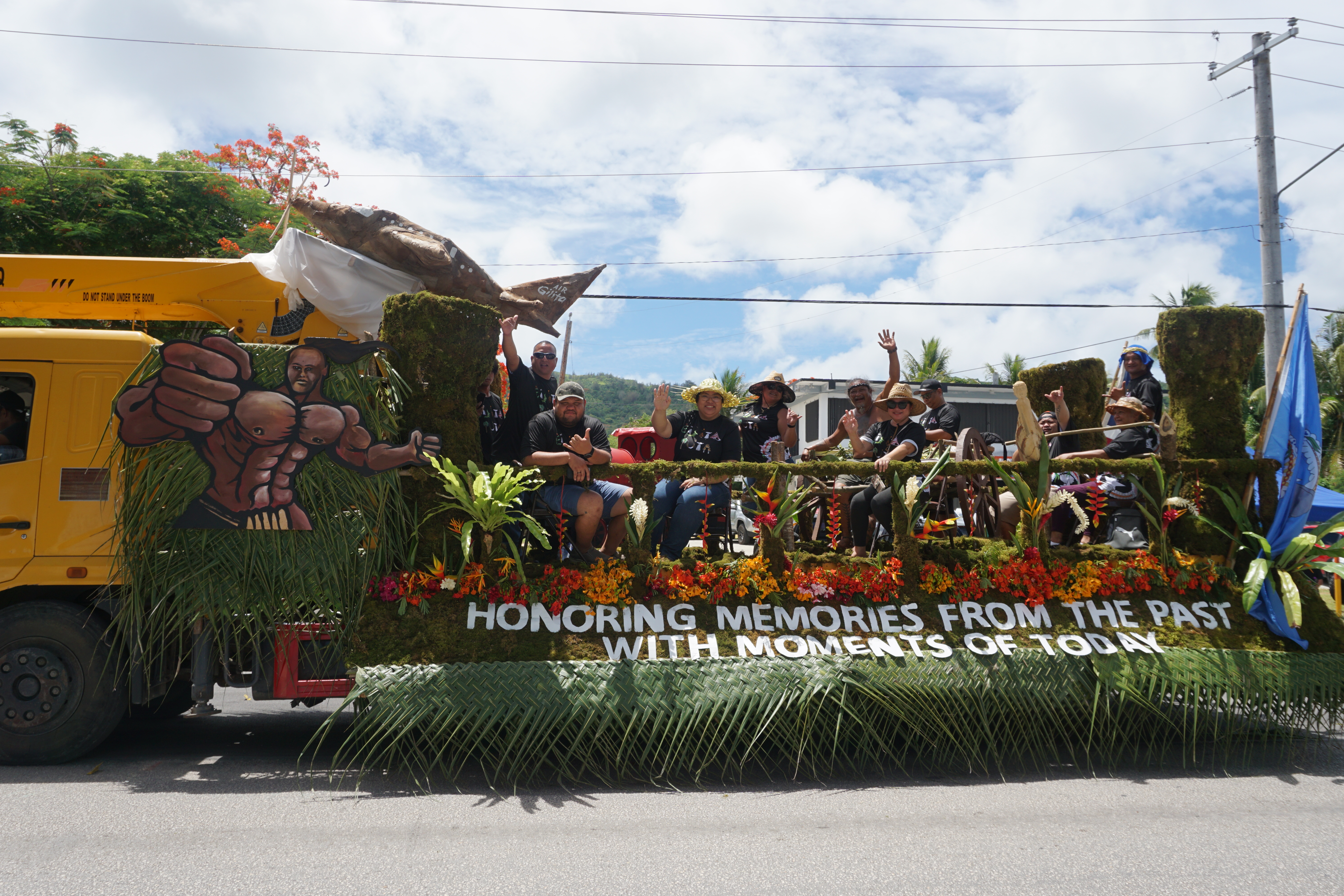 Rota Mayor Aubry Hocog, third left, waves to the camera aboard their float.​