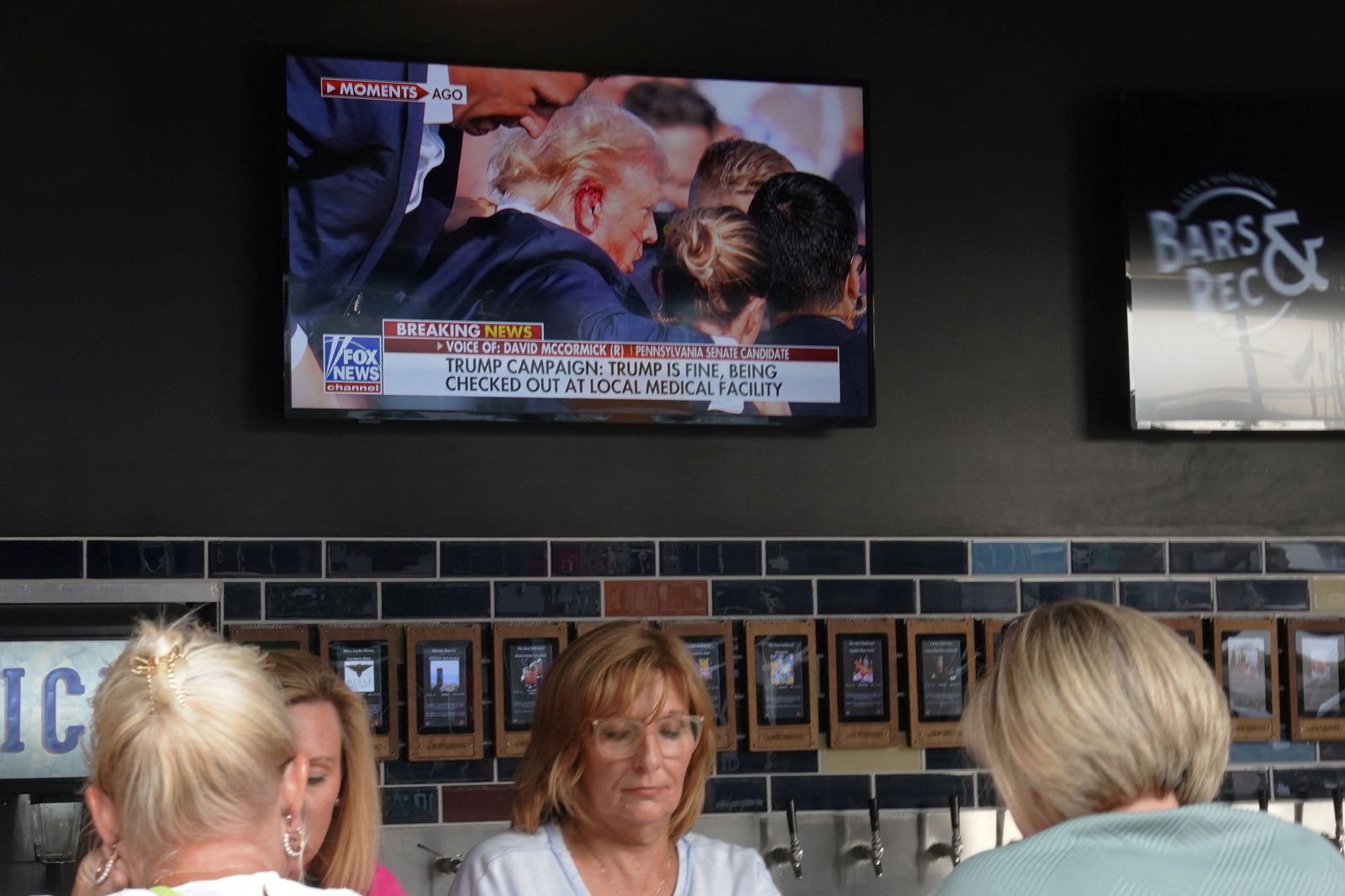 A television in a restaurant shows the news after reports of multiple shots fired and apparent injuries to Republican presidential candidate Donald Trump at his rally in Pennsylvania, outside the site of the 2024 Republican National Convention in Milwaukee, Wisconsin, July 13, 2024.
