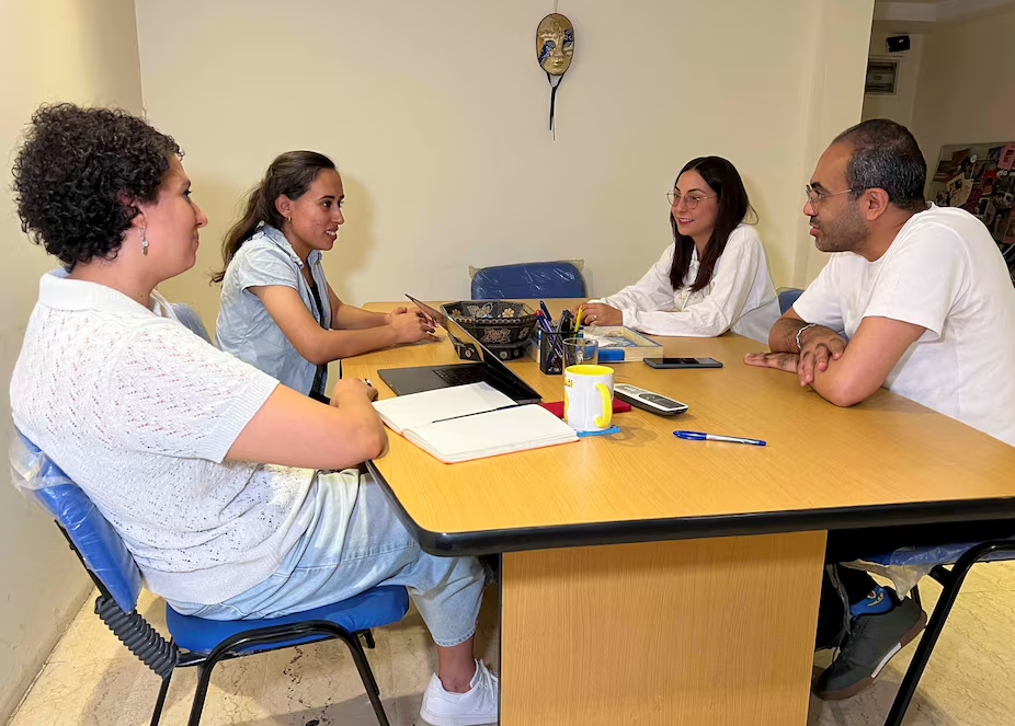 Crewmembers of the Egyptian documentary film "The Brink of Dreams" speak with members of the "Panorama El Barsha" street theatre troupe, in Cairo, Egypt, July 3, 2024.