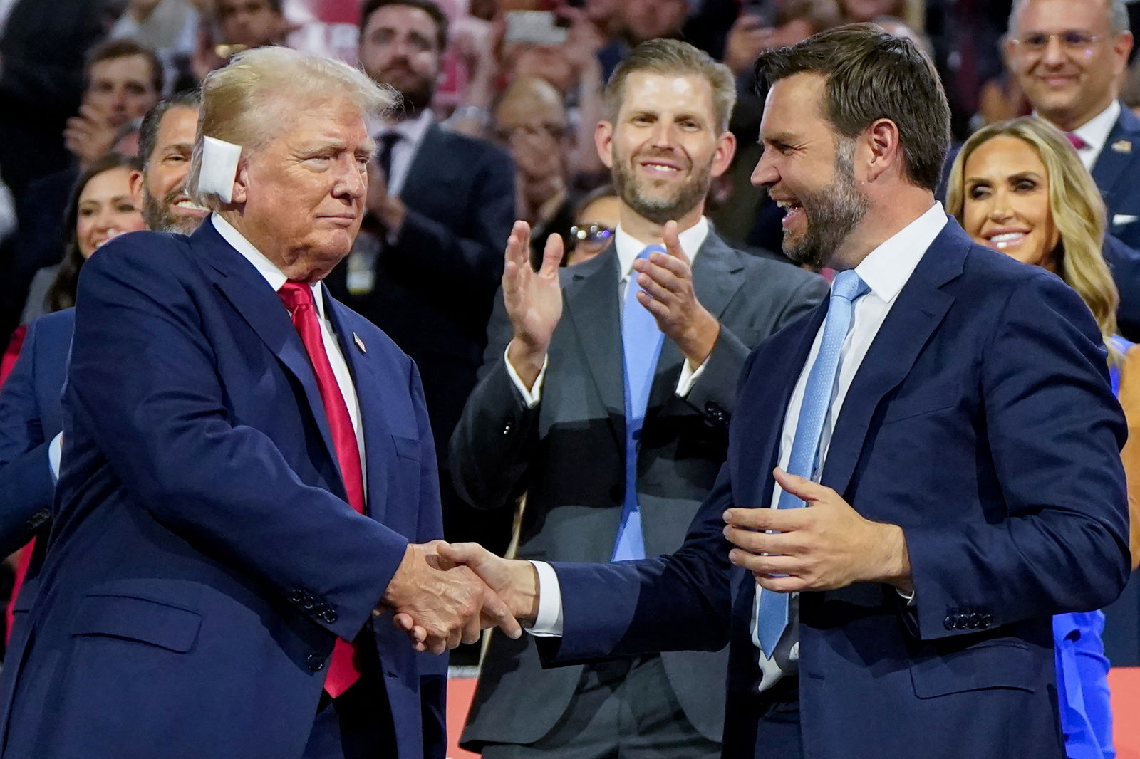 Republican presidential nominee Donald Trump and his running mate, Sen. J.D. Vance, shake hands as the former president’s son, Eric Trump, watches during Day 1 of the Republican National Convention at the Fiserv Forum in Milwaukee, Wisconsin, July 15, 2024.