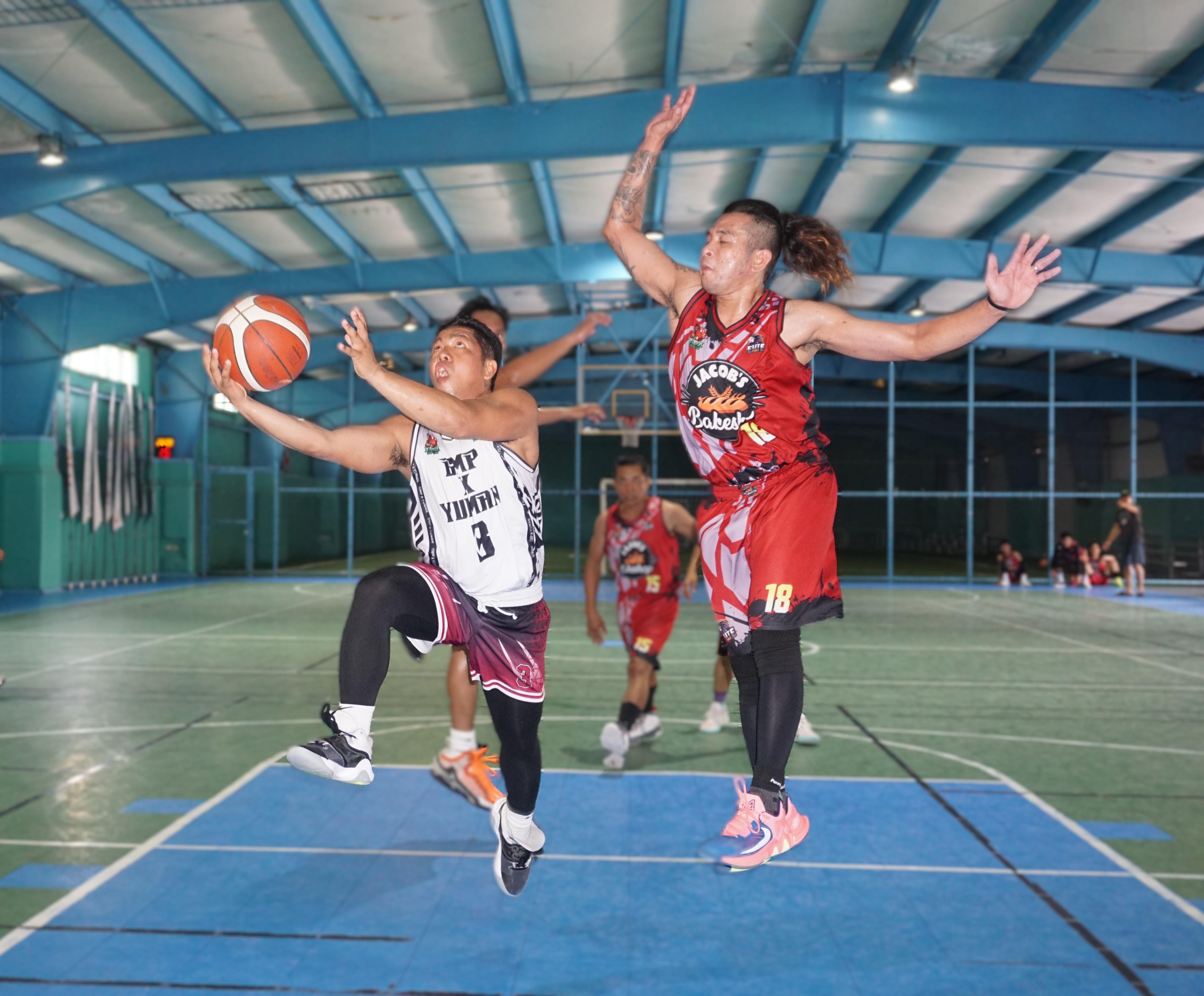 GMP x Yuman's Jether Medina extends for the right-hand finish against Jacob's Bakeshop's Jerome Reyes during a game in the Destroyers Basketball Club Invitational Basketball League 2024 at the TSL Sports Complex on Sunday.
