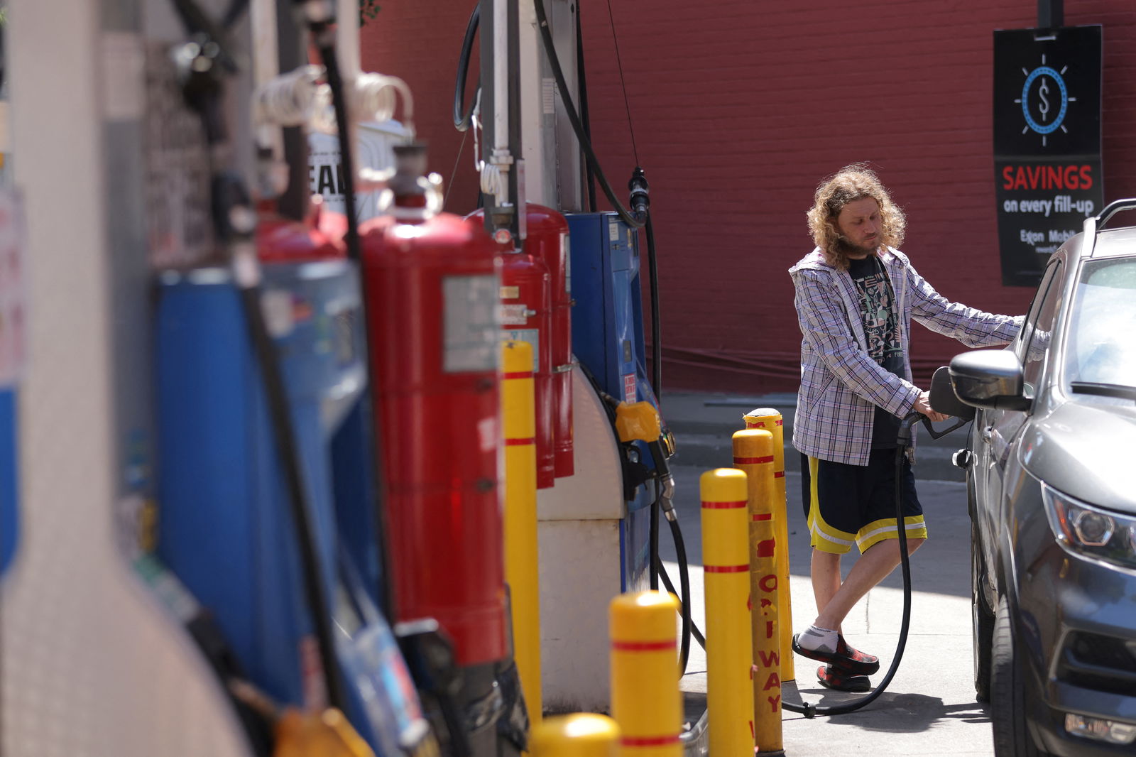 A person puts gas in a vehicle at a gas station in Manhattan, New York City, Aug. 11, 2022.