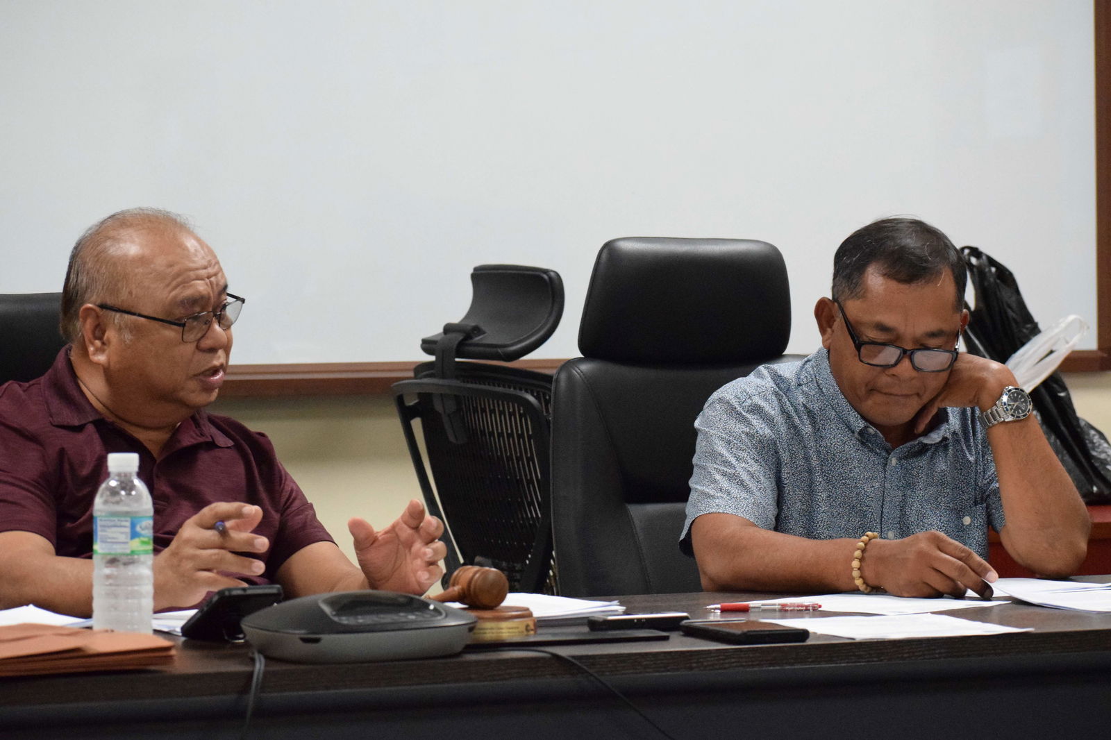 Commonwealth Casino Commission Chairman Edward C. Deleon Guerrero, left, speaks while Vice Chairman Ralph Demapan reads a document during the commission's monthly meeting on Friday.