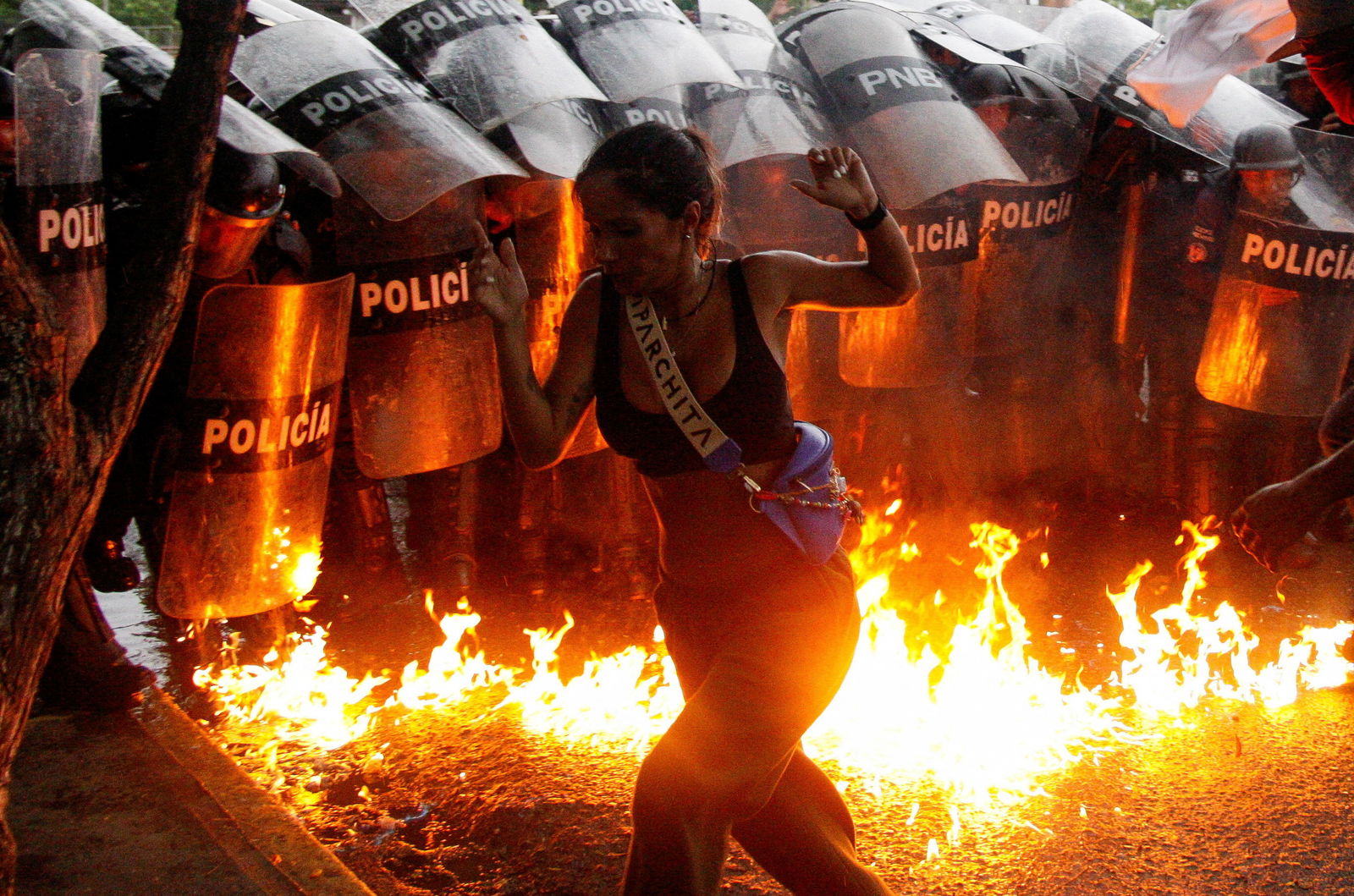 A demonstrator reacts when Molotov cocktails hit the ground in front of security forces during protests against election results after Venezuela's President Nicolas Maduro and his opposition rival Edmundo Gonzalez claimed victory in Sunday's presidential election, in Puerto La Cruz, Venezuela, July 29, 2024.