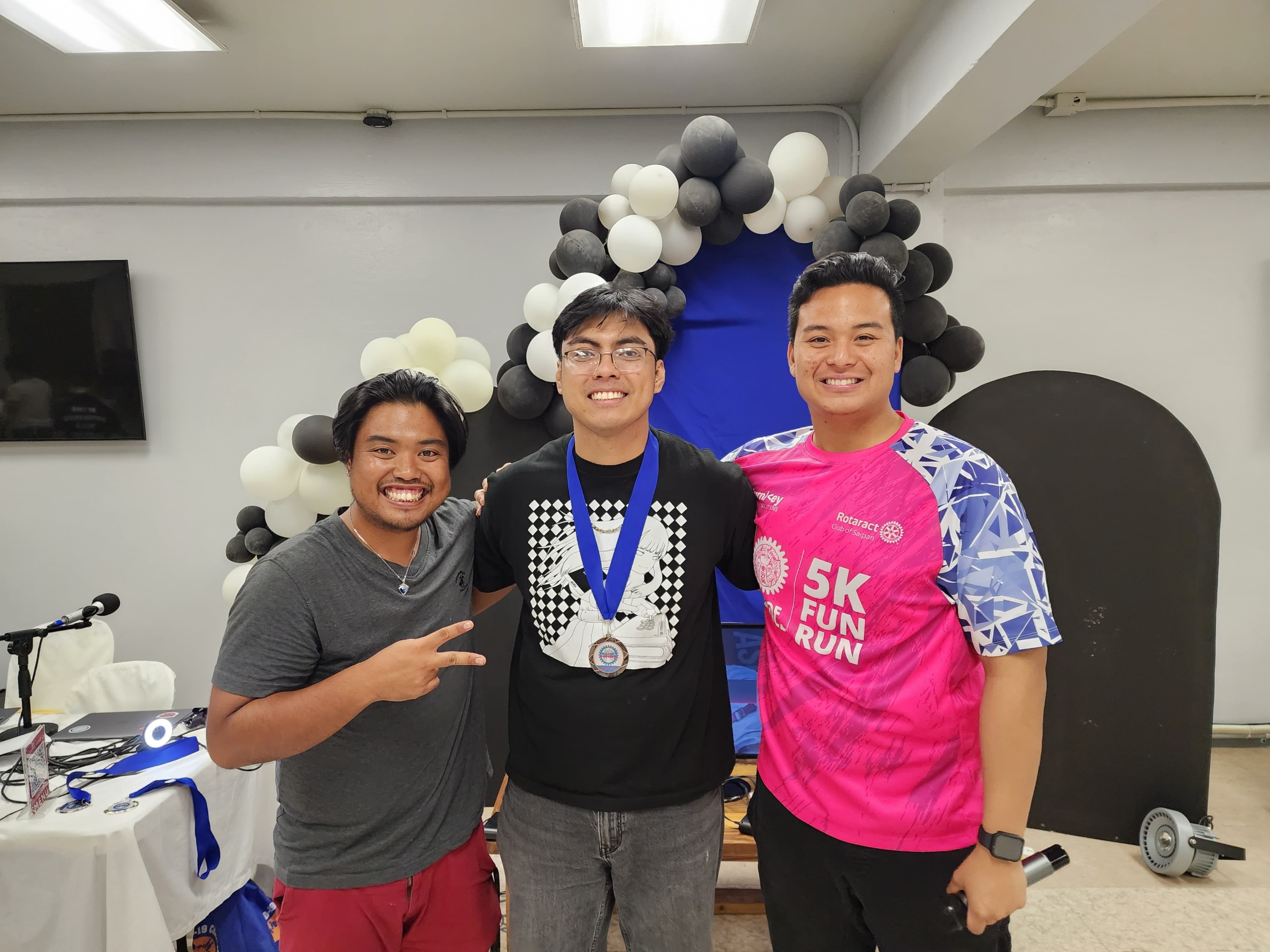 Lester “C.O.W.” Garcia, who placed third, poses with Rotaract Club of Saipan President Richard Baleares and tournament committee head Simon Necesito.
