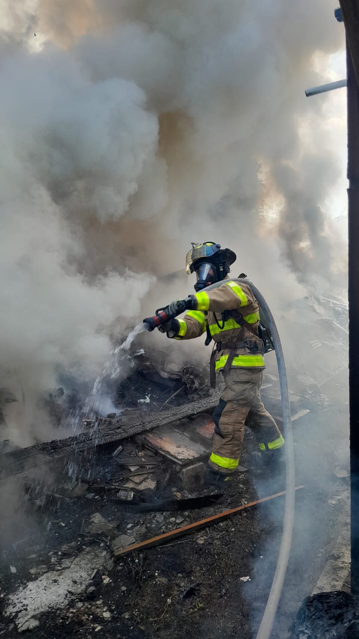 A firefighter snuffs out the flames in an area near a Navy Hill apartment on Monday, July 8, 2024.
