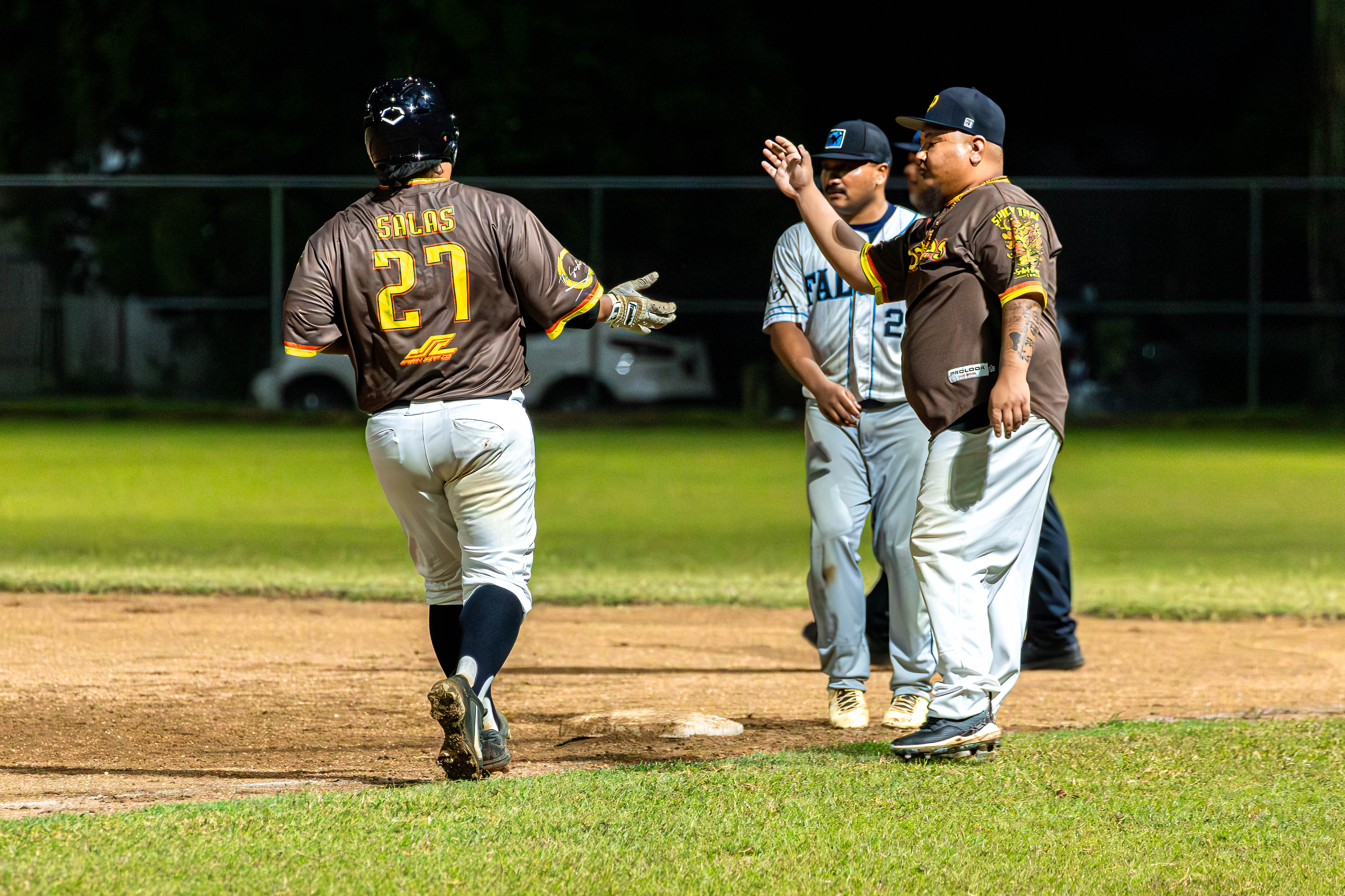 Padre's #27 Tony Salas daps up his base coach off a walk against the Falcons.