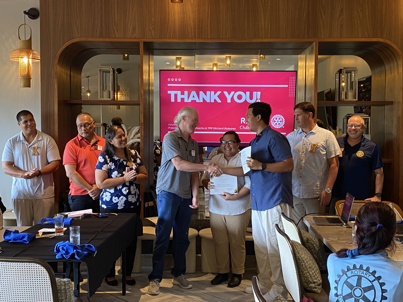 Outgoing Rotaract Club of Saipan President Richard Baleares shakes hands with Rotary Club of Saipan Vice President Brian Clayton.  