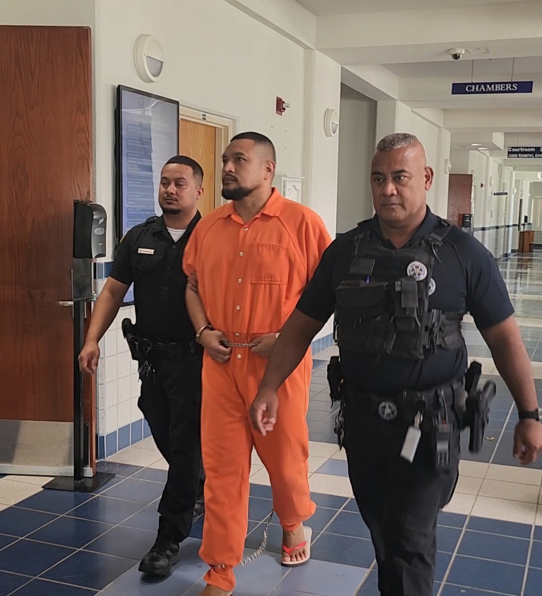 James Basa Camacho is escorted by a Corrections officer and a CNMI marshal to a bail hearing Monday morning.