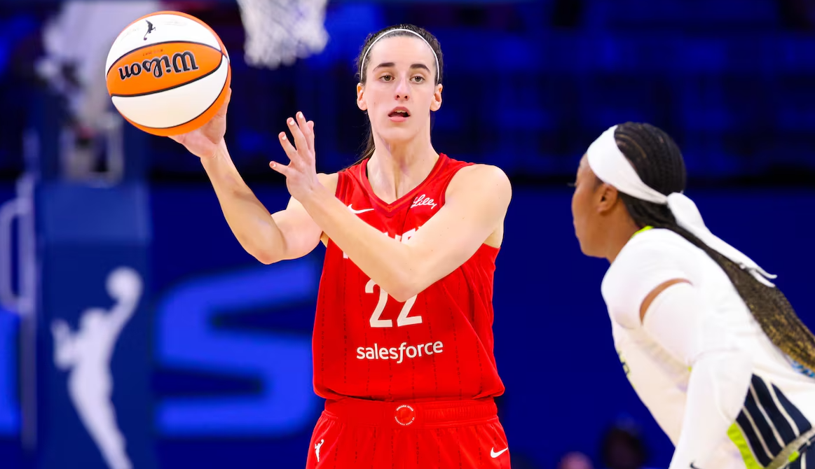 Indiana Fever guard Caitlin Clark (22) passes the ball past Dallas Wings guard Odyssey Sims (2) during the second half of a WNVA game at College Park Center in Arlington, Texas, July 17, 2024.