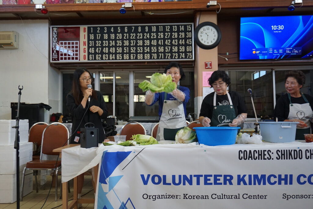 Visitors from Shikdo, Korea teach the manamko' how to process a cabbage and turn it into kimchi.