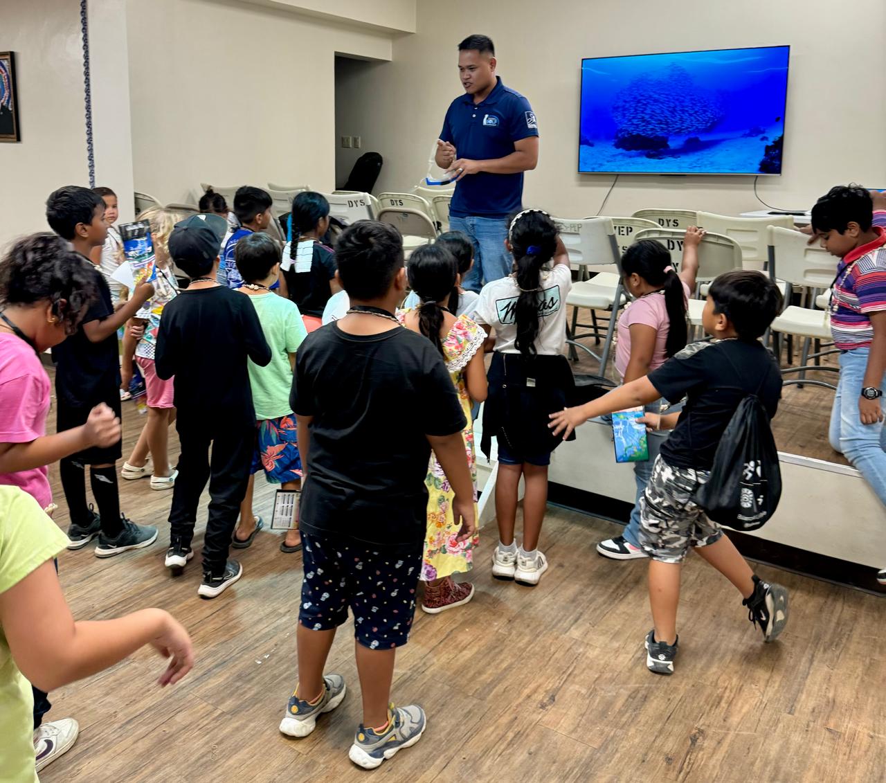 Children at the Division of Youth Services Youth Empowerment Summer Camp prepare for an imaginary dive at Obyan Beach with Marianas Visitors Authority Community Projects Specialist Jack Aranda on July 24, 2024, in Koblerville.