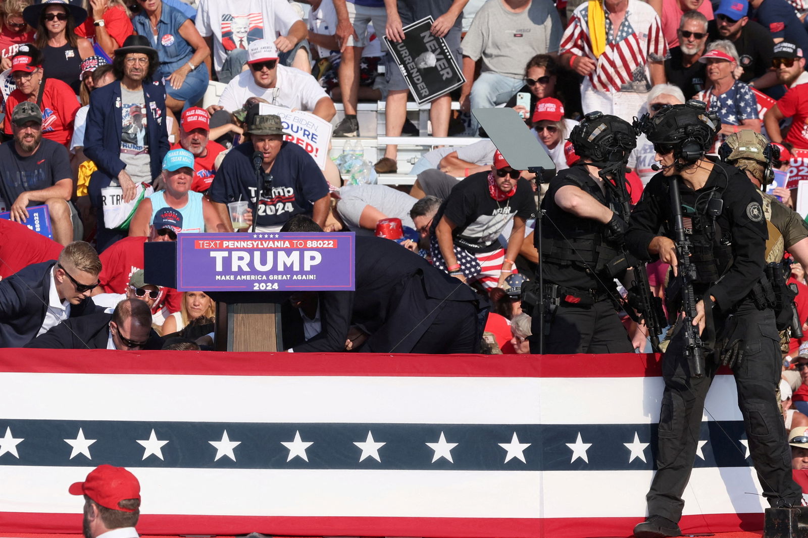 Republican presidential candidate Donald Trump is assisted by U.S. Secret Service personnel after gunfire rang out during a campaign rally at the Butler Farm Show in Butler, Pennsylvania, July 13, 2024. 