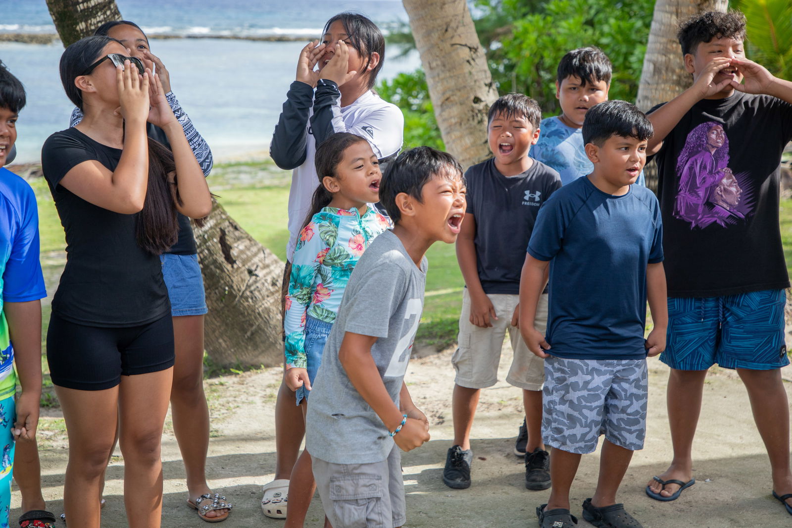 Campers and counselors sing camp songs at the beach in Rota.