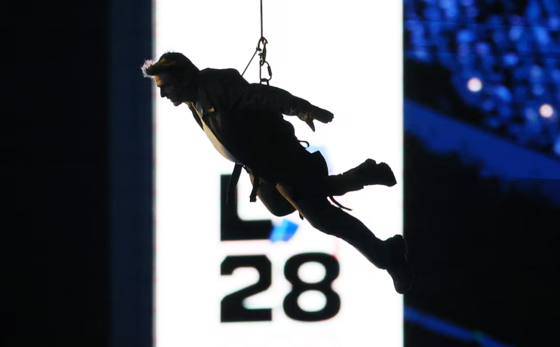 Actor Tom Cruise rappels from the roof of France's national stadium during the closing ceremony of the Paris Games on Sunday night, Aug. 11, 2024.