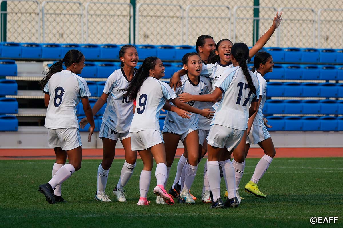 The NMI's Aubrey White celebrates with her teammates after scoring a goal against Macau.