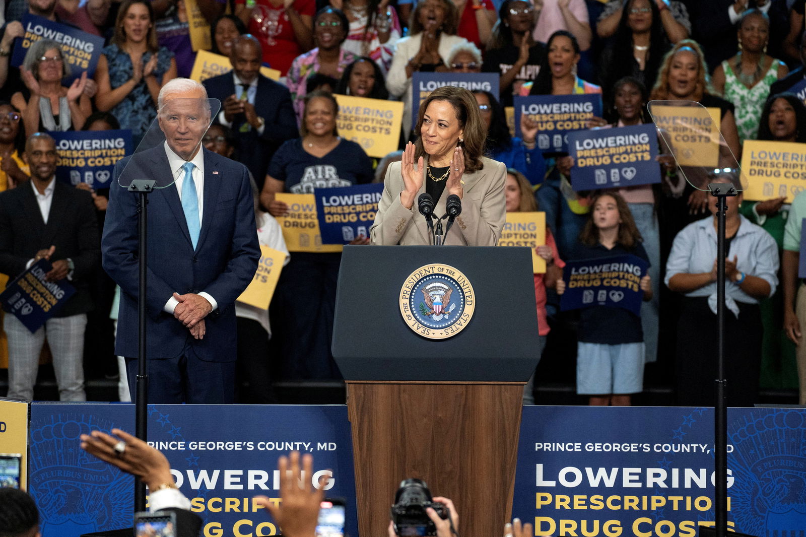 Vice President and Democratic presidential candidate Kamala Harris delivers remarks as President Joe Biden looks on at an event on Medicare drug price negotiations, in Prince George's County, Maryland, Aug. 15, 2024.