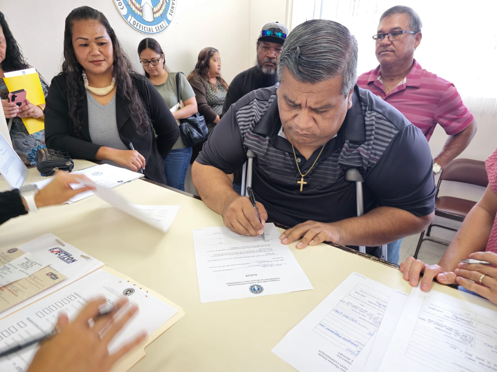 Antonio Suda Kapileo, a CNMI Republican Party candidate for Precinct 4, certifies his intent to run for the House of Representatives at the Commonwealth Election Commission on Wednesday, Aug. 7, 2024. Also in photo is his running mate, Rose T. Rios, left, NMI GOP President Diego T. Benavente, right, and supporters.