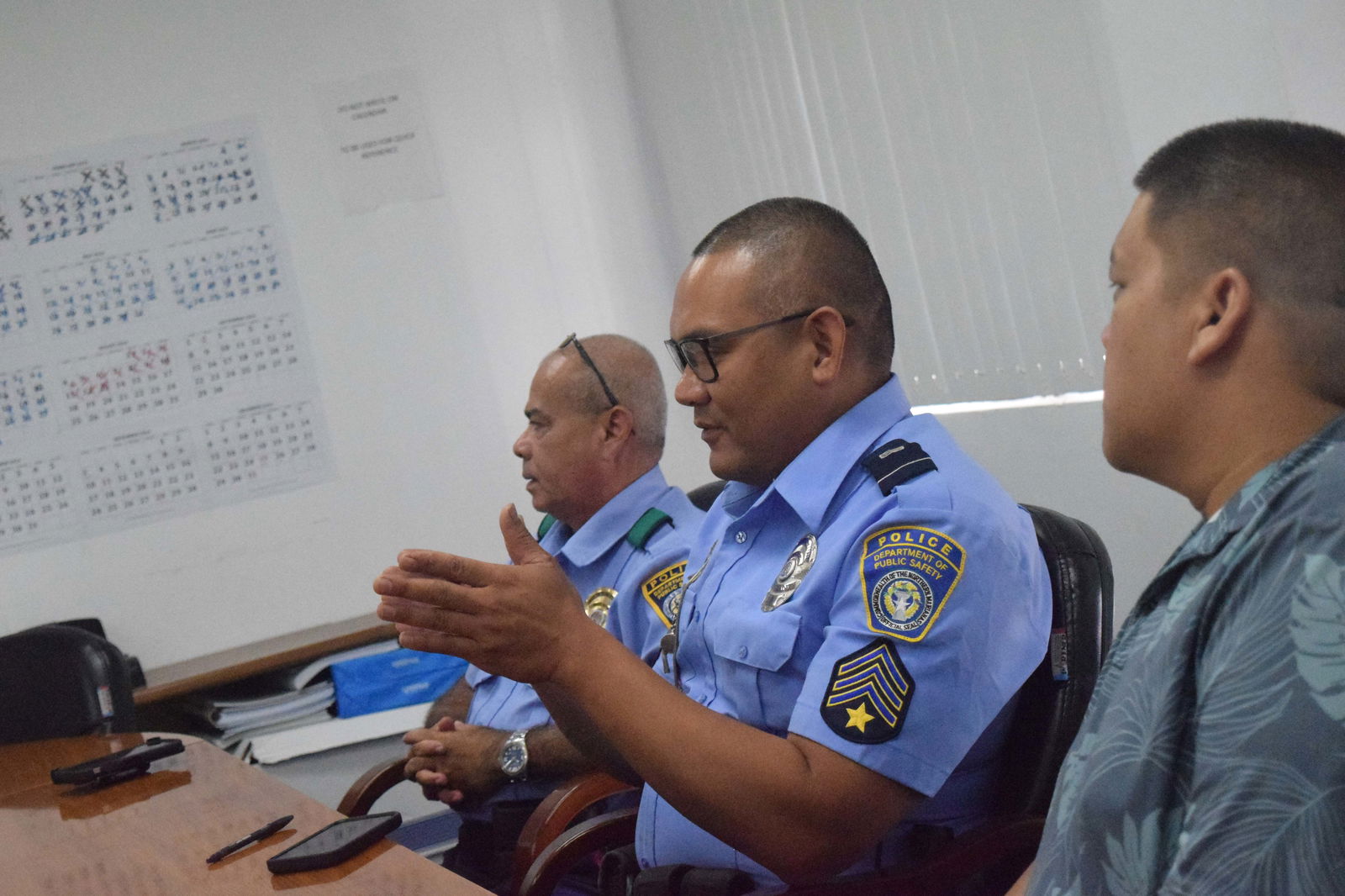 Department of Public Safety Sgt. Adrian Mendiola, center, gestures as he speaks as Lt. Daniel Smith, left, and Public School System Pupil Transportation Director Shaun San Nicolas listen.