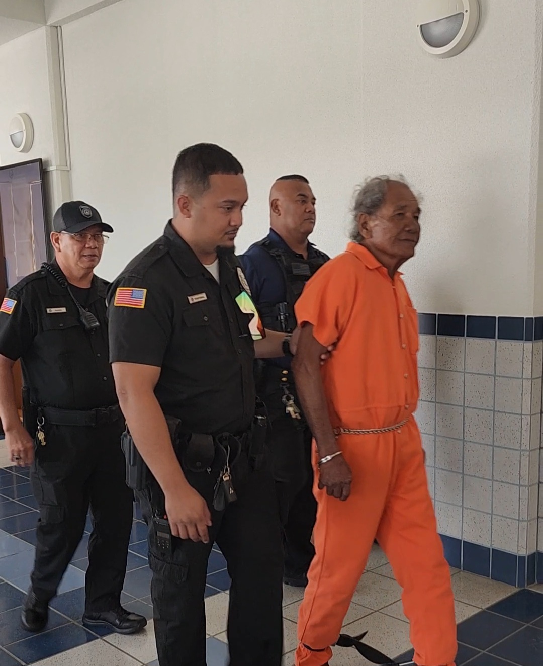 Moses Pangelinan Cabrera, 78, is escorted by Corrections officers and a CNMI Marshal after a bail hearing at the Guma’ Hustisia on Monday morning.
