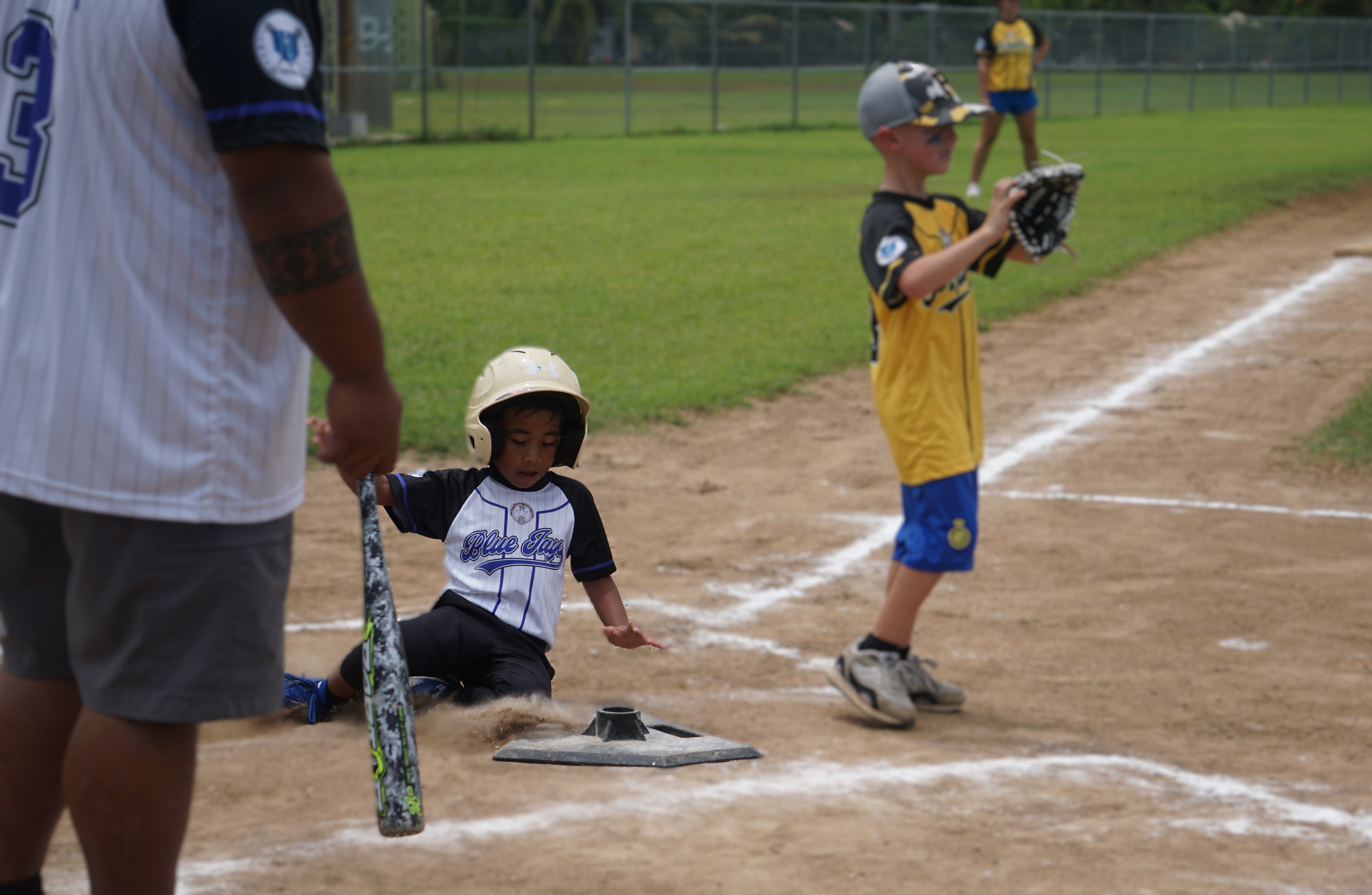 A Blue Jay slides home safely for an earned run during a game against the Pirates in the NMI Softball Association's inaugural T-Ball League at the Francisco "Tan Ko" Palacios baseball field. 