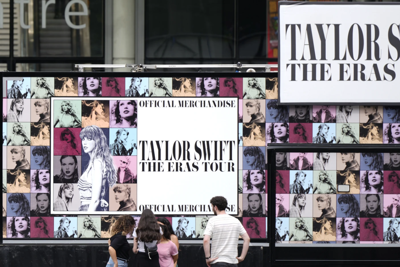 A family looks at a Taylor Swift merchandise kiosk at Wembley Stadium in London, Wednesday, Aug. 14, 2024, ahead of a series of concerts starting Thursday.