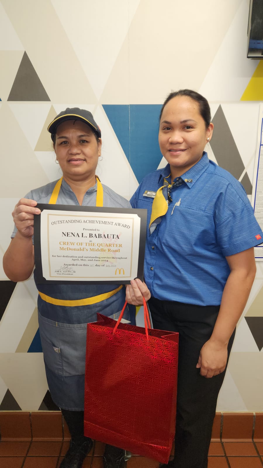 McDonald's Restaurant service crewmember Nena Babauta, left, receives the Crew of the Quarter Award from Chalan Laulau branch's general manager, Gisel Achas.
