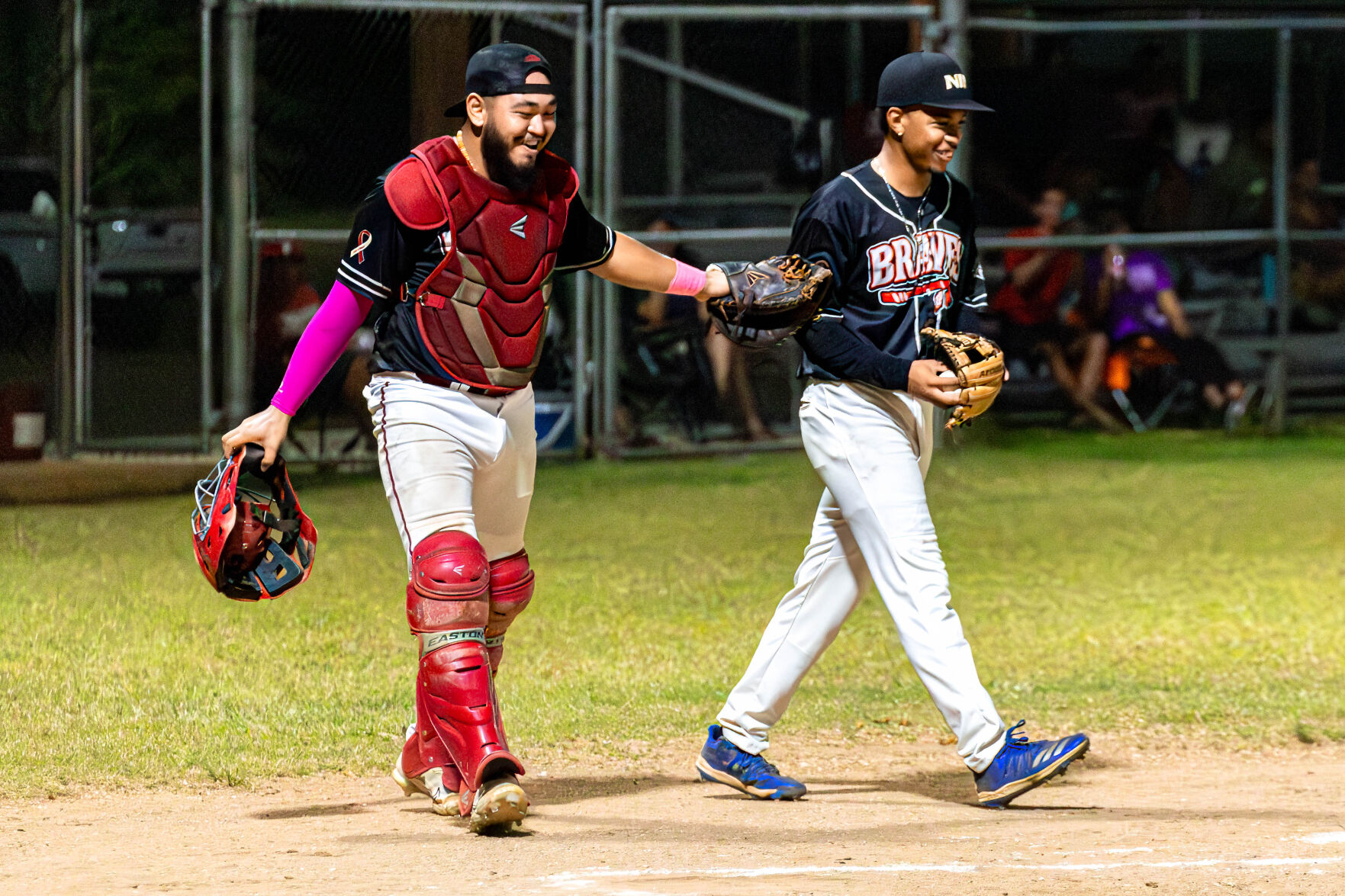 The Braves' pitcher Jylon Sablan and catcher Andrew Camacho smile after a successful defensive play during a game in the 2024 Tan Holdings Saipan Baseball League at the Francisco "Tan Ko" Palacios Baseball Field.