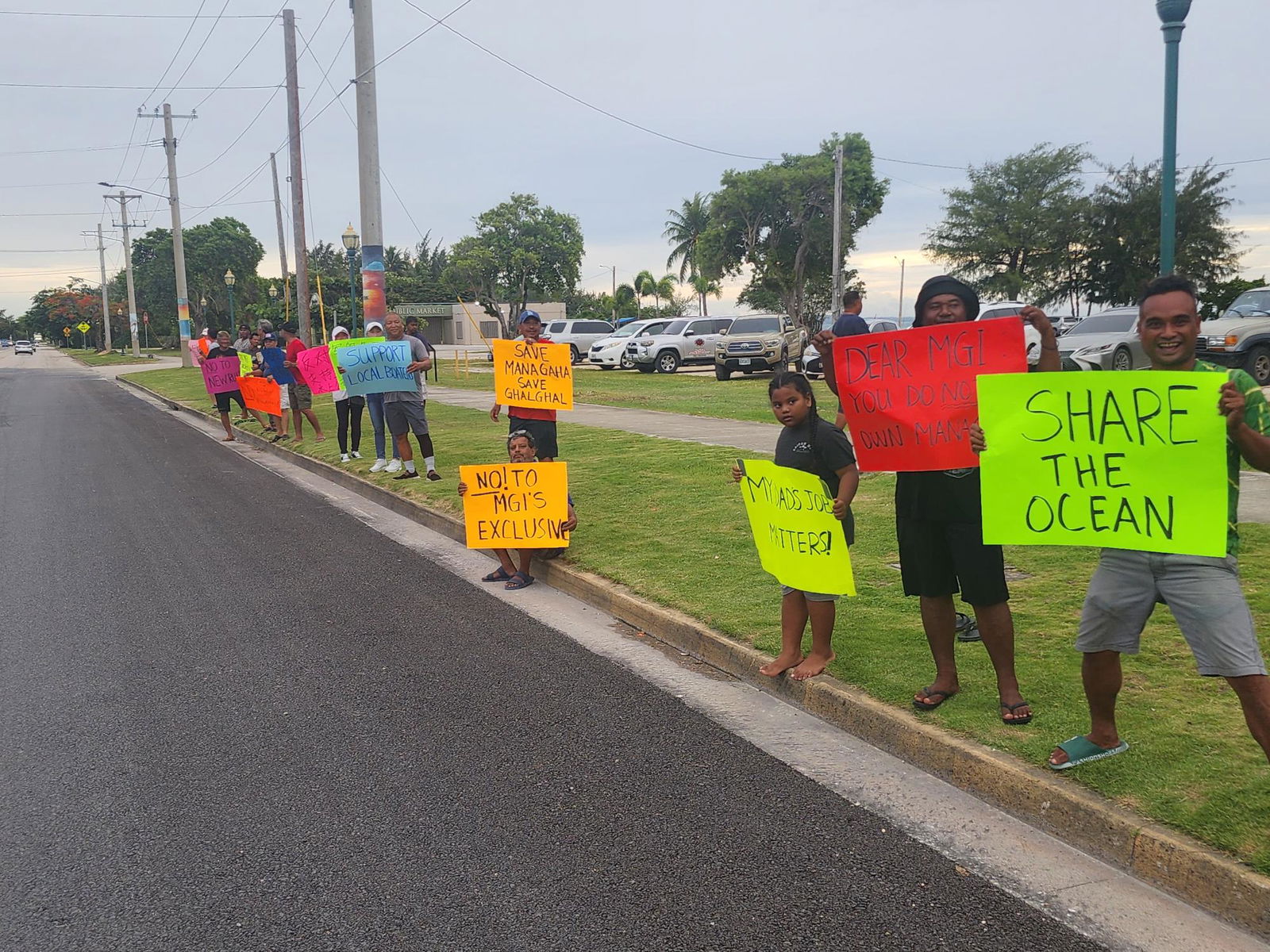 Boat captains, deck crews and marine sports operators hold signs to express their opposition to the proposed amendments to the rules and regulations pertaining to Managaha’s commercial use.   