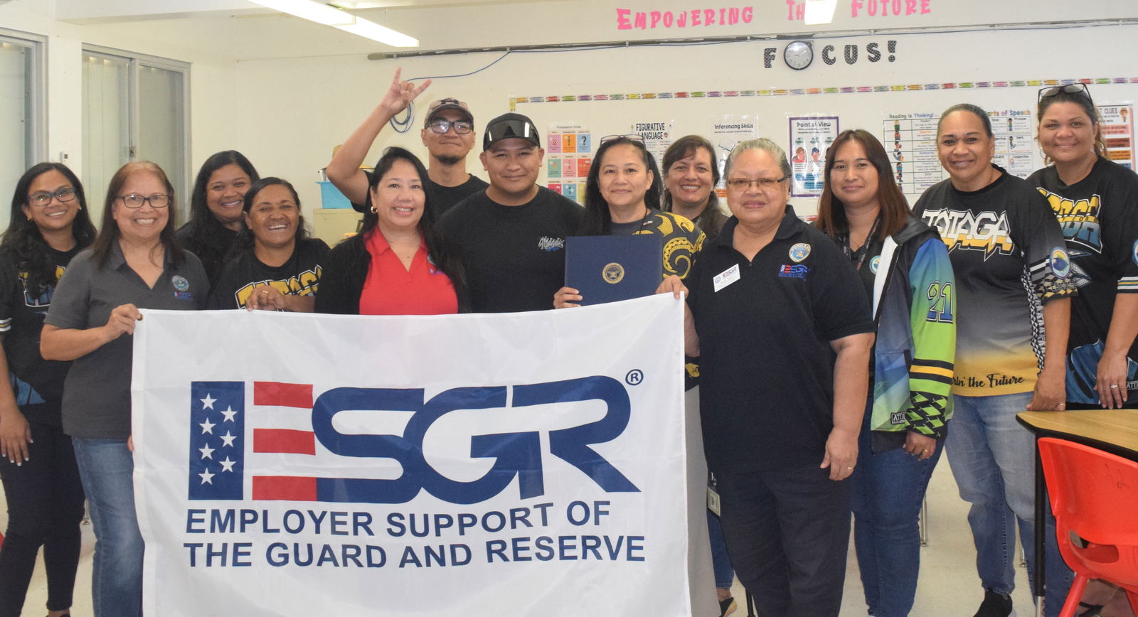 Tanapag Middle School Principal Hilda Rios, sixth right, poses for a photo with teachers and Guam-CNMI Employer Support of the Guard and Reserve State Committee officials after receiving the Patriot Award on Monday.