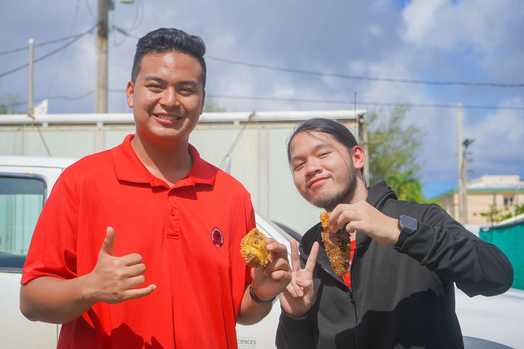 From left, Northern Marianas College students Richard Baleares and John David Cabrera pose with raw honey extracted as part of a beekeeping presentation and activity.