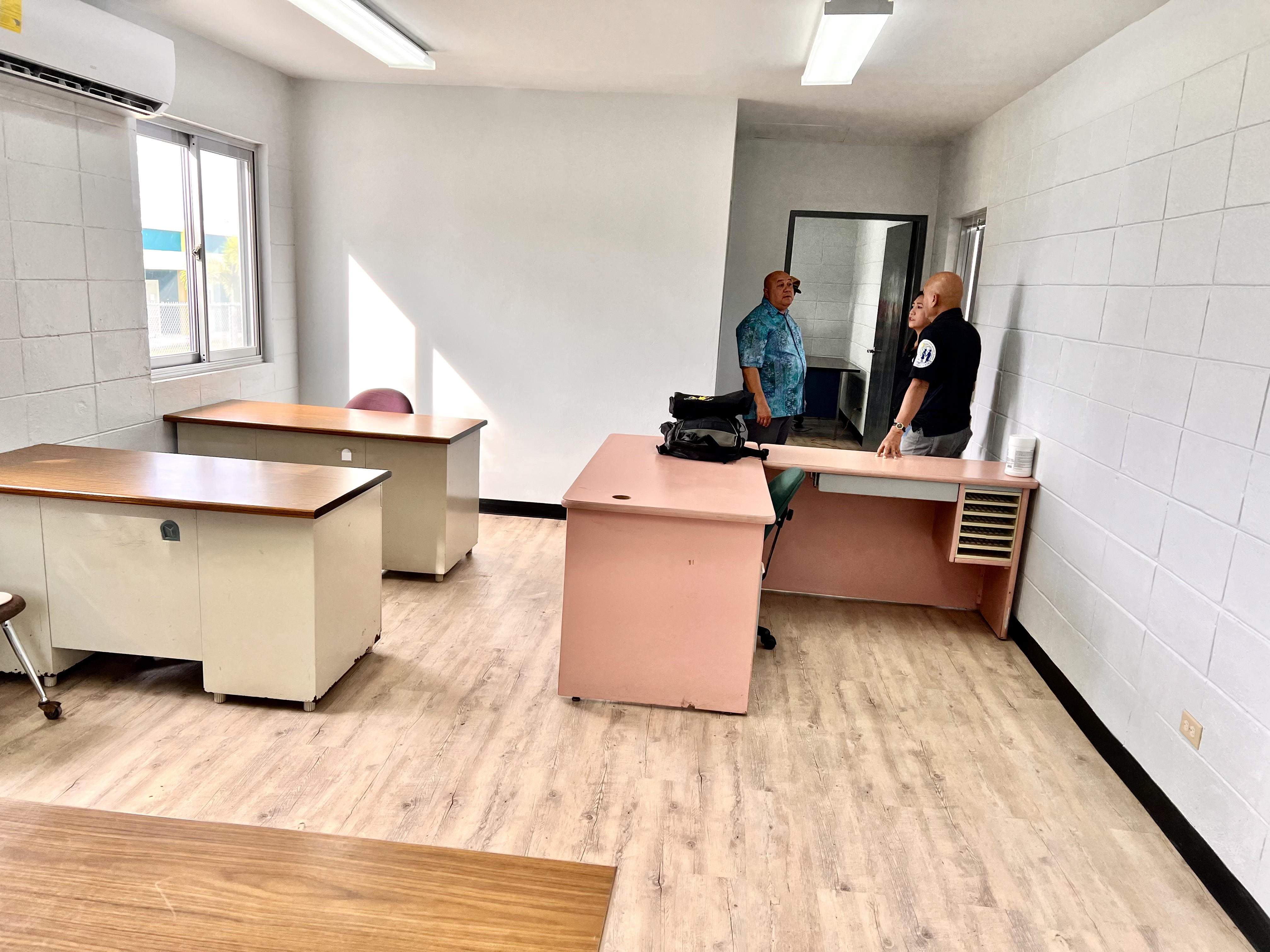 Commissioner of Education Dr. Lawrence F. Camacho confers with architectural technicians Rommel Mostales and Gemalyn Ramundo as he tours the interior of the new Rota OPT facility.