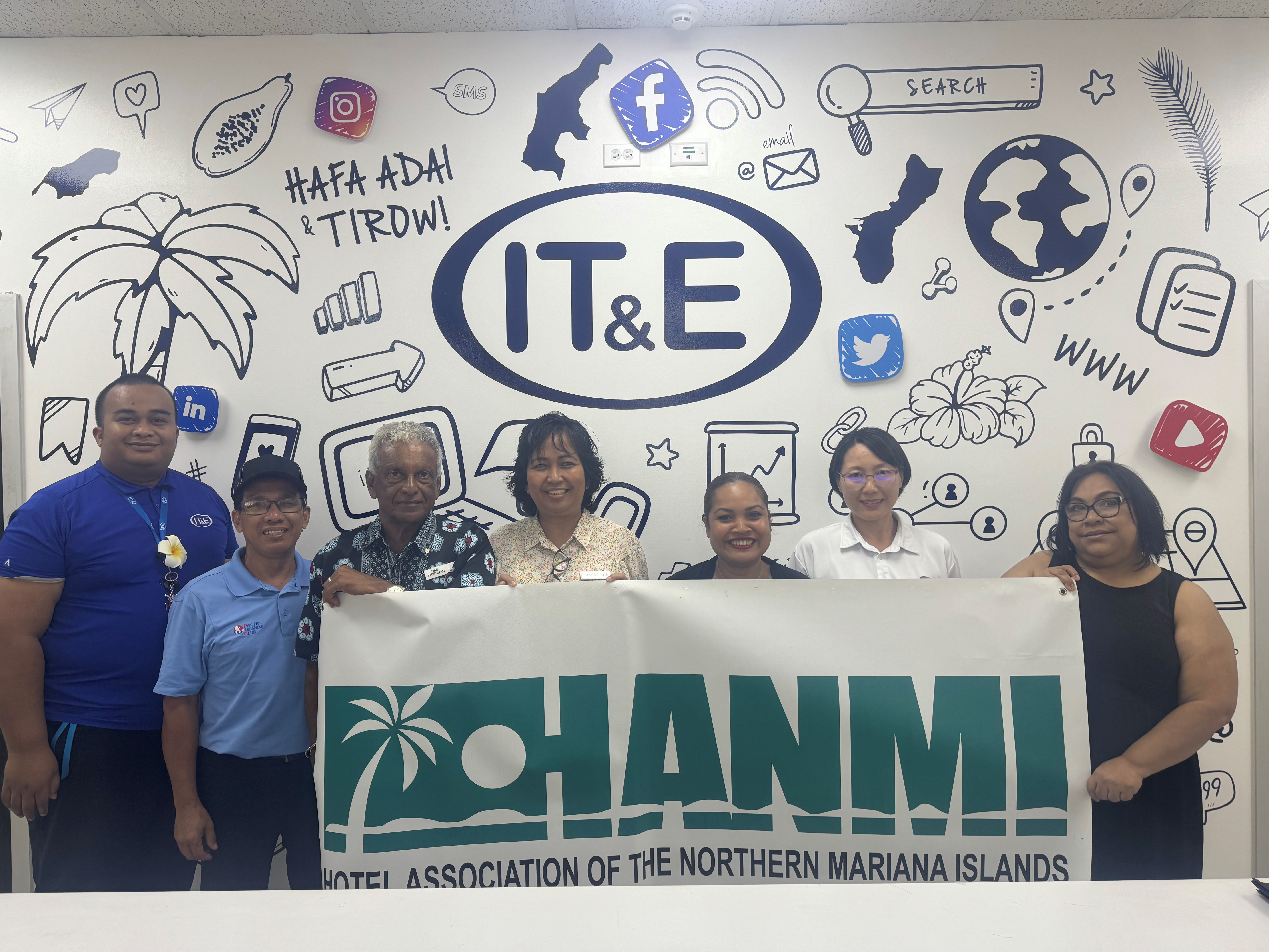 IT&E Senior Manager Janice Tenorio, far right, donates an iPhone 14 on Aug. 14, 2024, to the 22nd Annual HANMI Charity Classic Golf Tournament set for Aug. 24, 2024, at Coral Ocean Resort Saipan.  From left, IT&E Universal Service Representative Midcat Tipingeni, tournament committee member William Retardo, tournament committee chairman Das Krishnan, tournament committee members Loida Sabanal, Julie Litulumar, Noriko Watanabe, and Tenorio.
