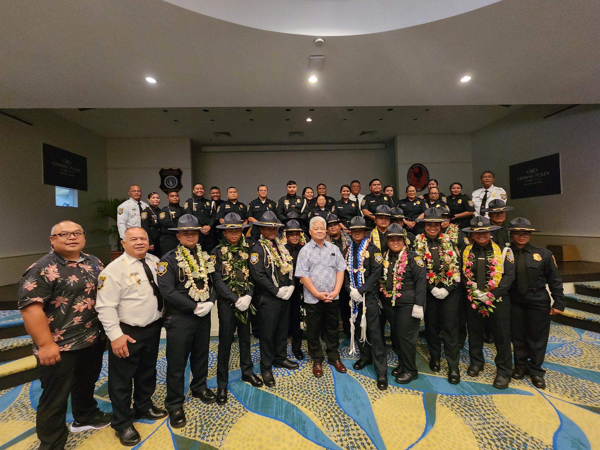 The 16 newly sworn in Customs officers pose for a photo with Gov. Arnold Palacios, Customs Director Jose Mafnas, Rep. BJ Attao, and other Customs officials at Crowne Plaza Resort’s Hibiscus ballroom on Friday.