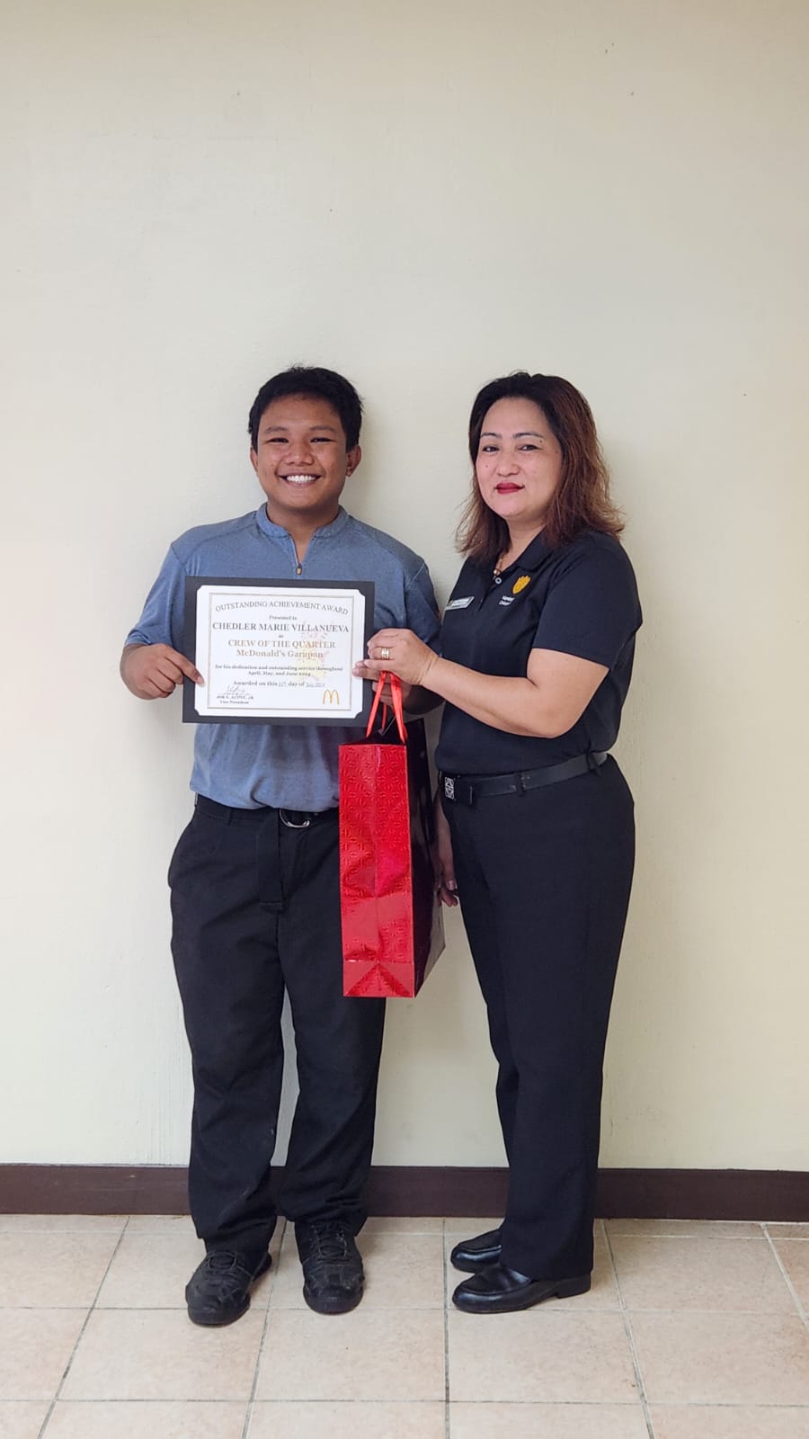 McDonald's Restaurant service crewmember Chedler Villanueva, left, receives the Crew of the Quarter Award from Garapan branch general manager Ruthzel Perez.