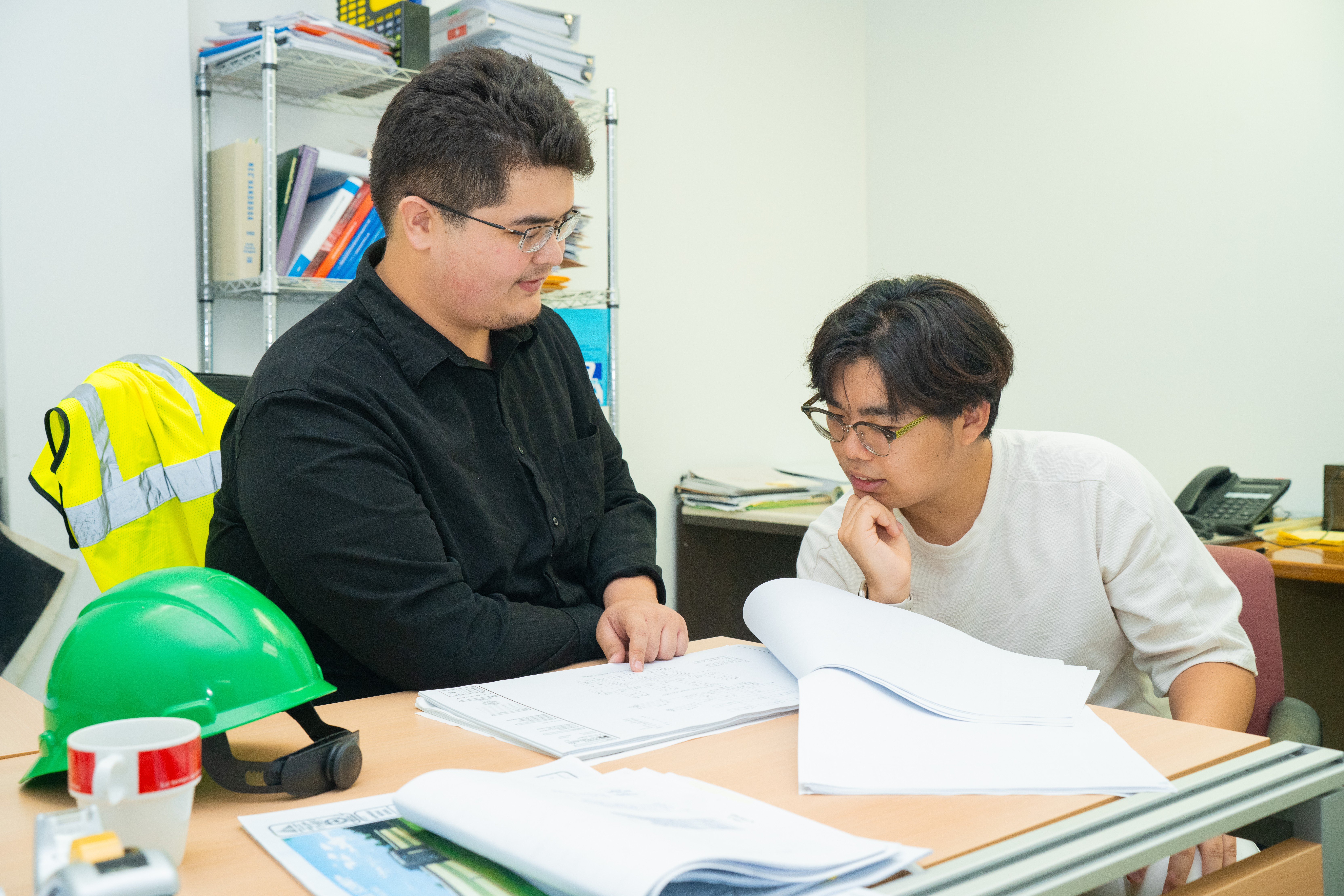 NMC Pre-Engineering students Kyle Attao, left, and Isaac Han review DPW design blueprints and documents.