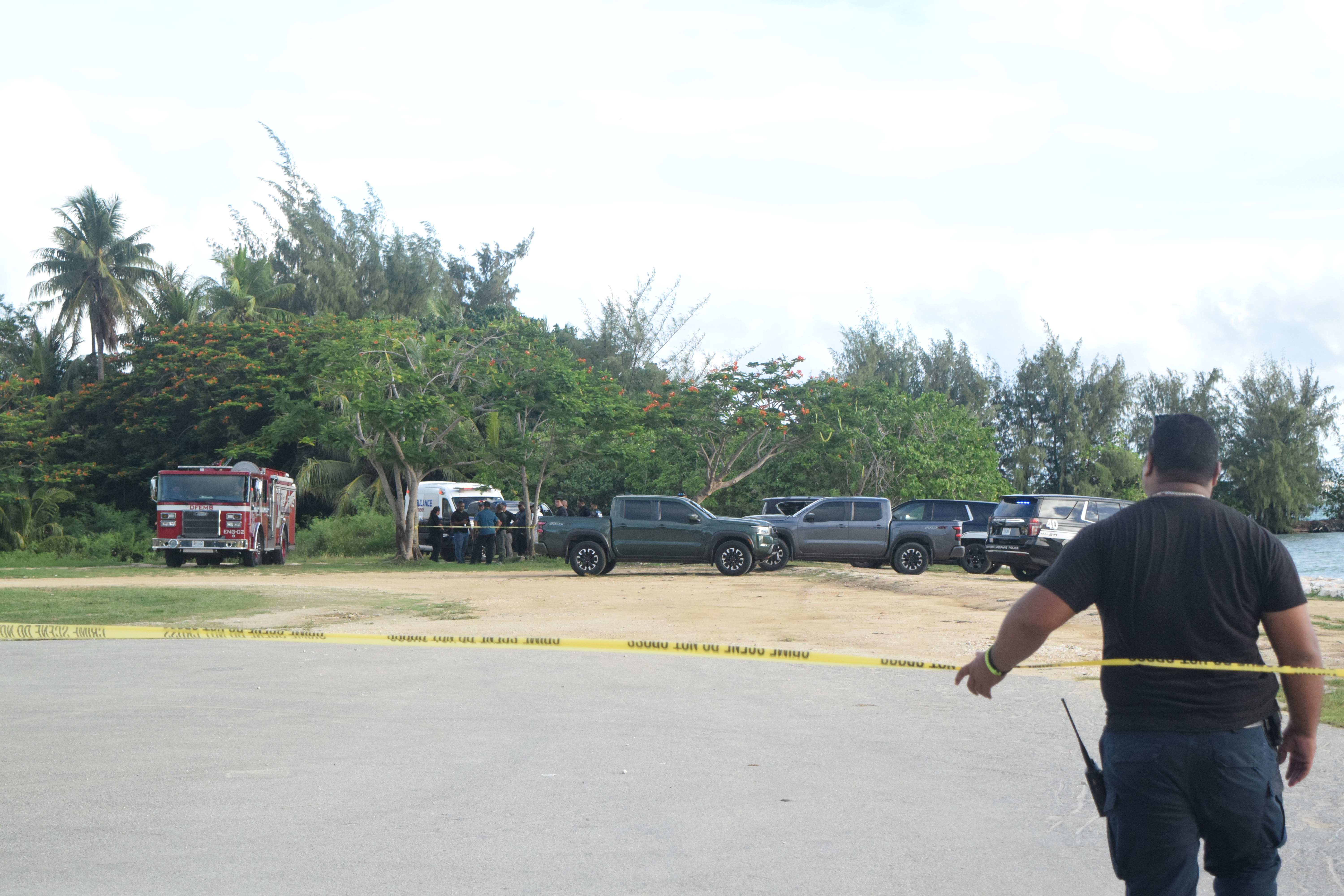 A Department of Public Safety officer stands near a barricade tape at the Garapan Fishing Base as Criminal Investigation Bureau detectives investigate a possible crime scene at 5:20 p.m. on Thursday.