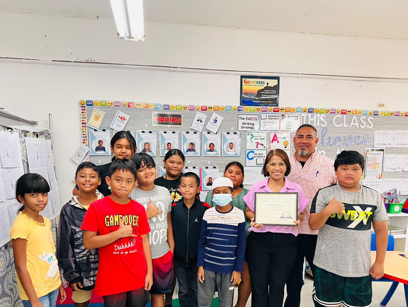 Third-grade classroom teacher Jenina Manglona poses for a photo with her students after she was selected  as the state-level winner of the prestigious President Awards for Excellence in Mathematics and Science Teaching.