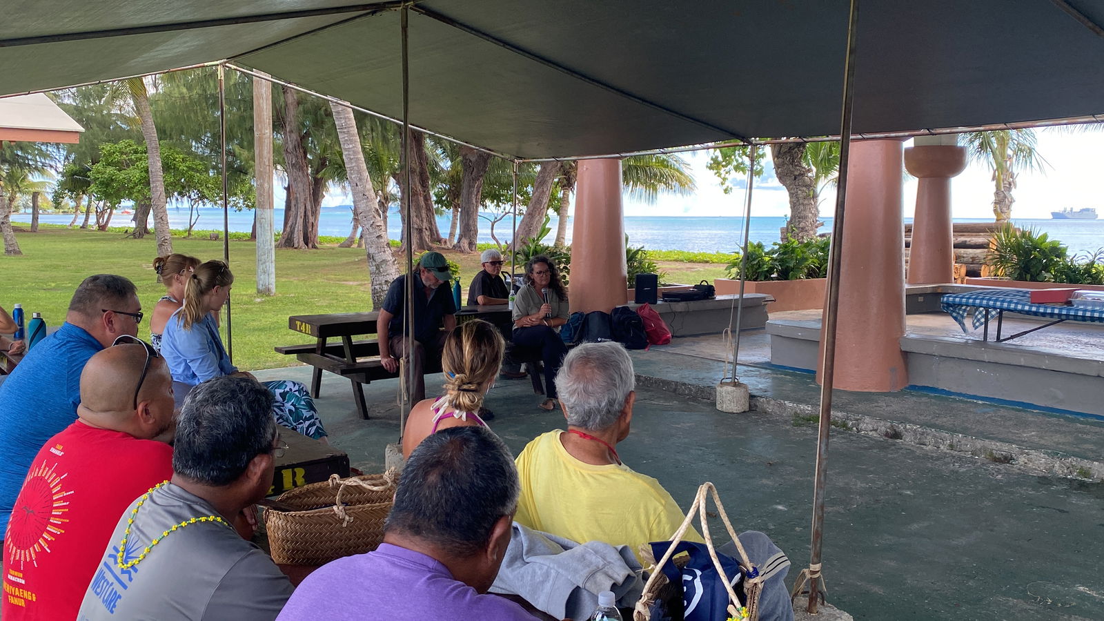Jennifer McKinnon, holding a microphone, speaks at a meeting with community members at the Carolinian Utt on Tuesday, Aug. 13, 2024.