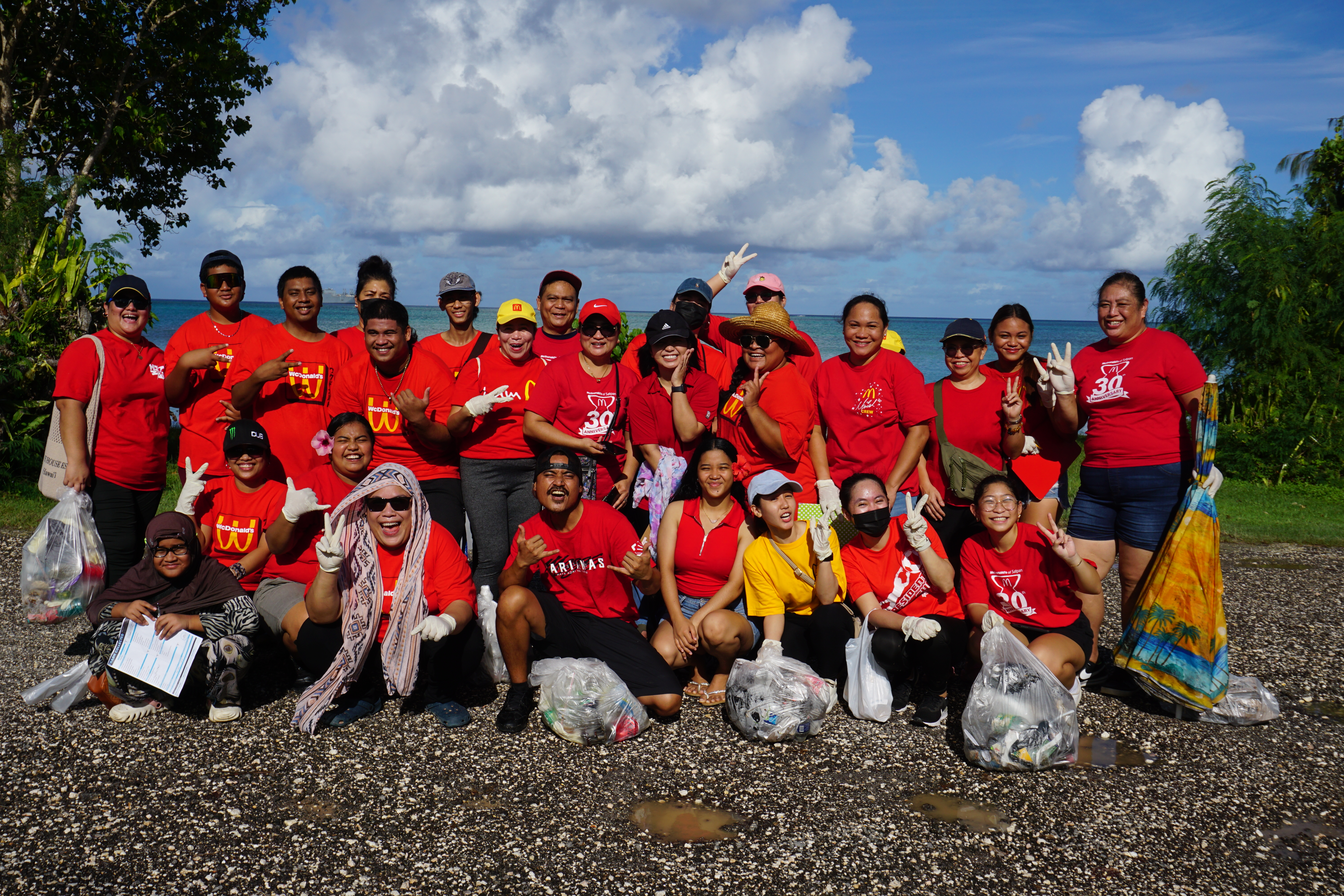 McDonald’s employees pose for a group photo during a break from their cleanup activity at the Garapan Fishing Base on Saturday.