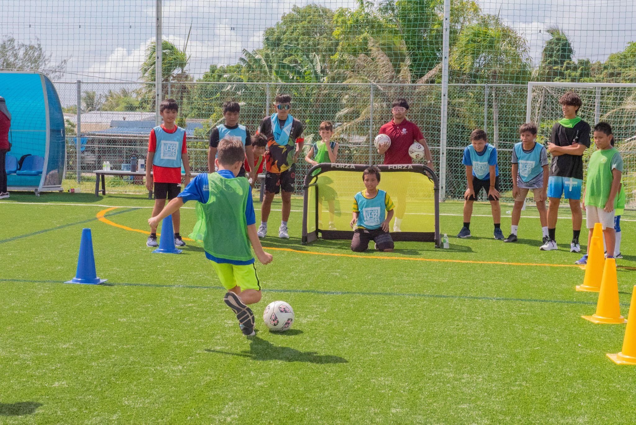 Campers and counselors enjoying a hands-on soccer demo at the Koblerville Soccer Training Center.