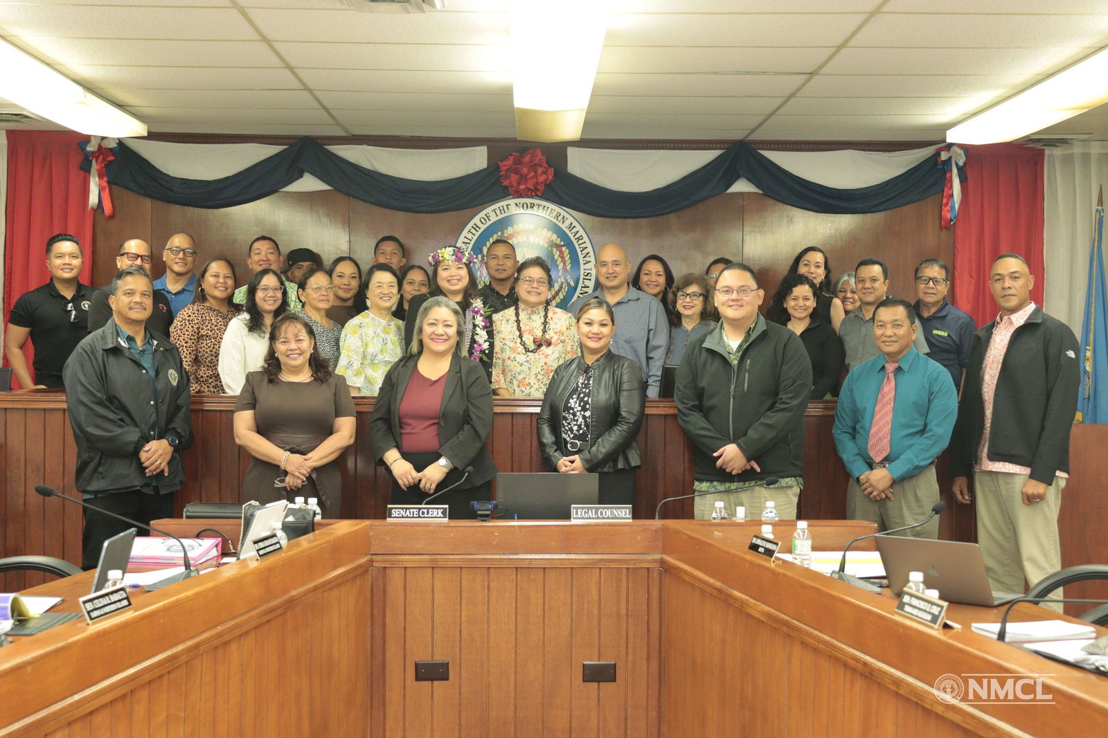 Newly confirmed Board of Professional Licensing members Elizabeth Balajadia and Roy P. Reyes, and Northern Marianas College Regent Michelle Lin Sablan pose for a photo with families, friends and senators on Friday in the Senate chamber.